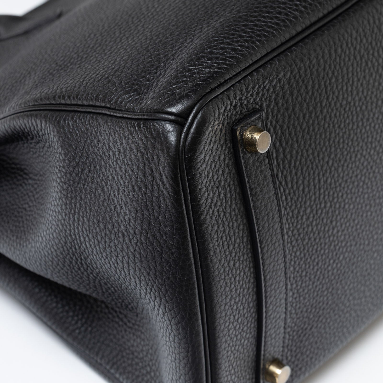 Close-up of bottom corner on Hermès Birkin 35 Black Togo Gold Hardware showing textured leather and gold feet