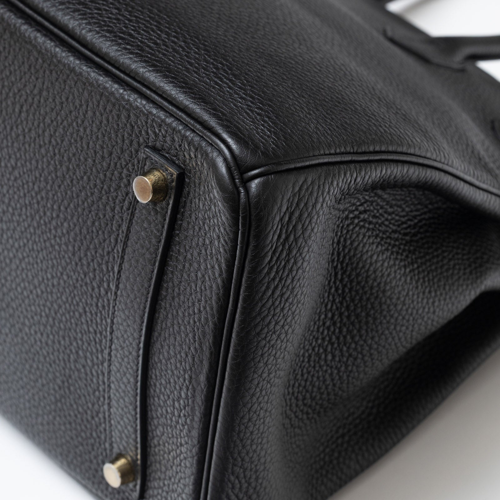 Close-up of the corner and gold hardware on Hermès Birkin 35 Black Togo Gold Hardware handbag.