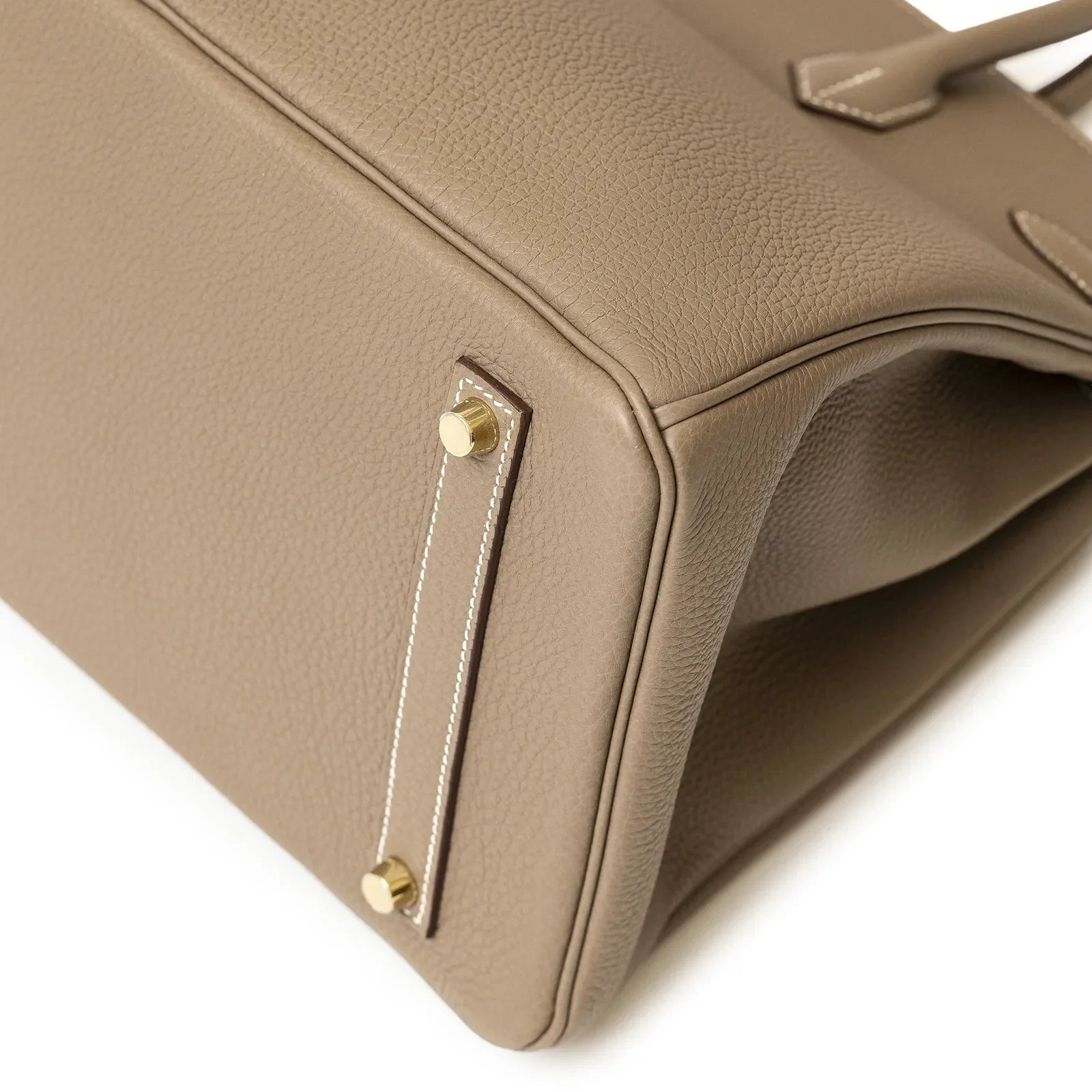 Close-up of base corner of Hermès Birkin 35 Etoupe Togo Gold Hardware showing leather texture and gold feet.
