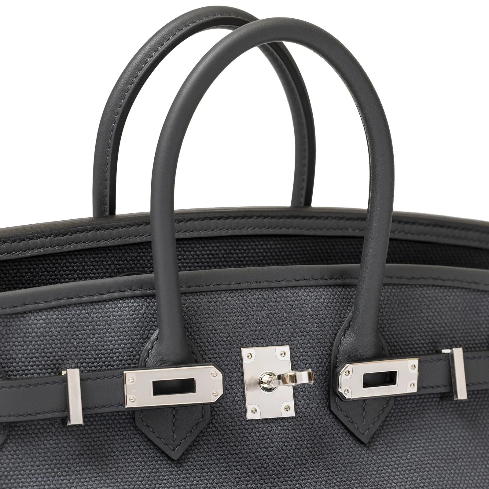 Close-up angled shot of grey canvas Hermès Birkin Cargo 25 showing palladium hardware and leather handles.