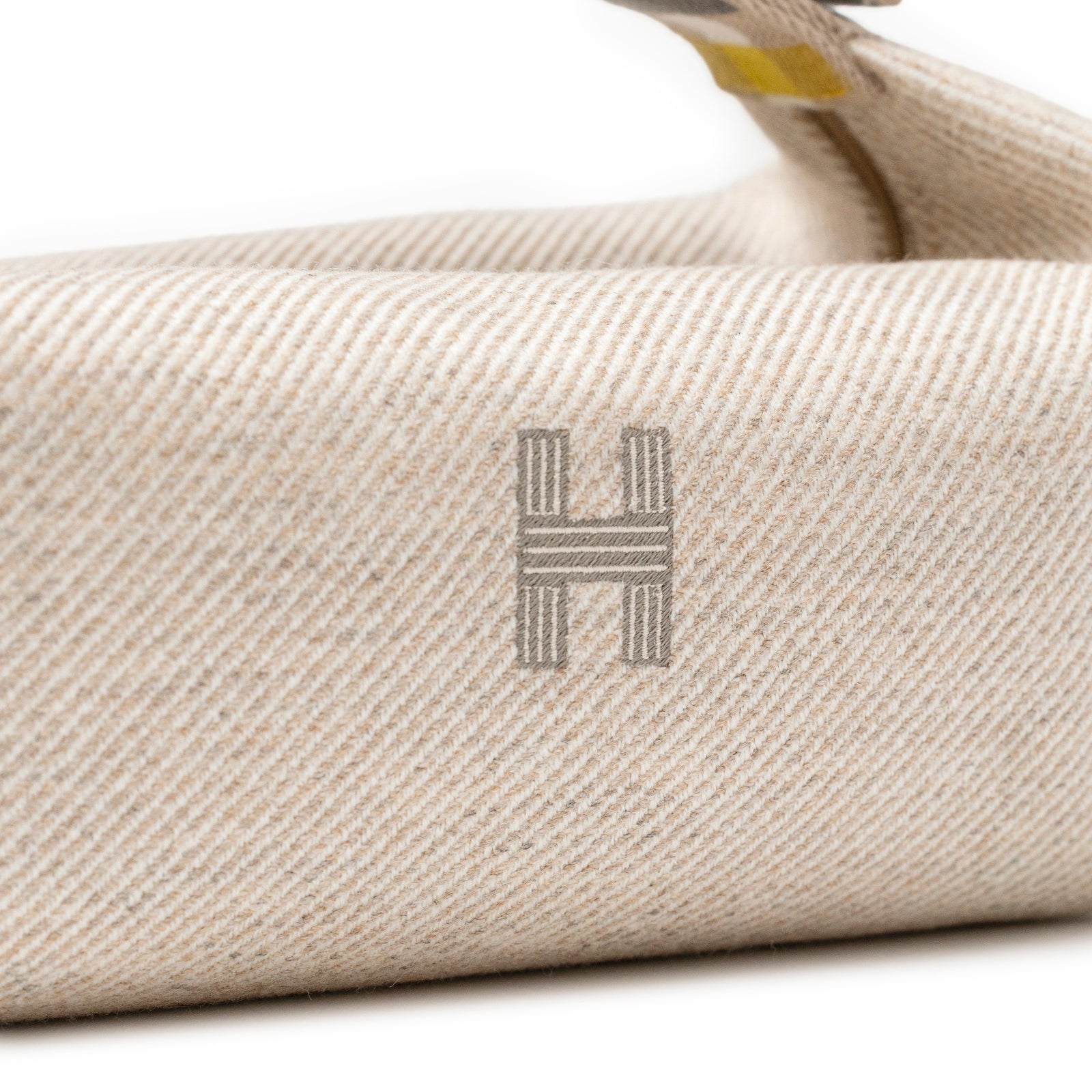 Close-up of beige fabric texture with subtle striped pattern on Hermès Bride-a-Brac au Carre Case Small Model Seigle