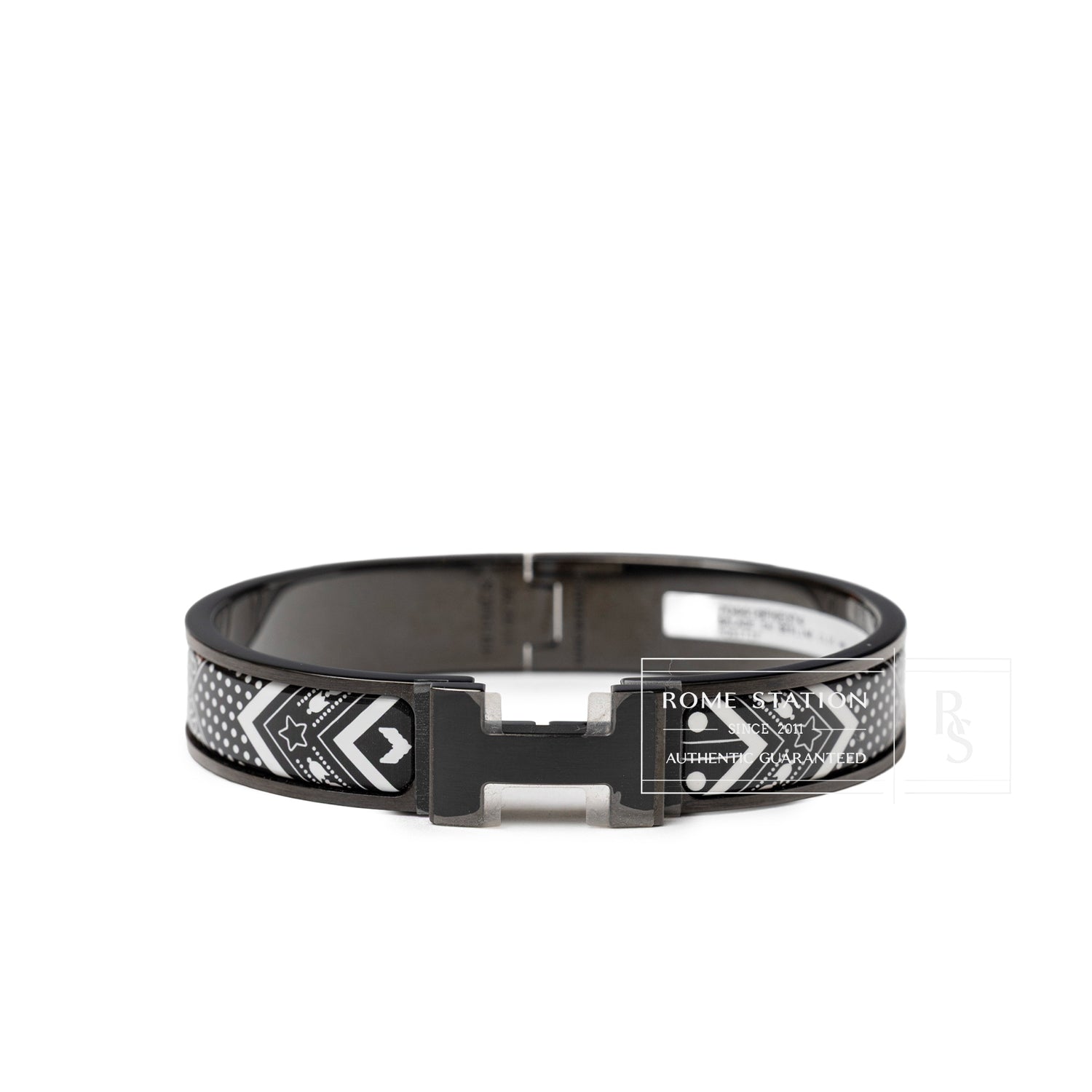 Front view of Hermès Clic HH Bandana So Black Bracelet Positif with black and white patterned enamel band