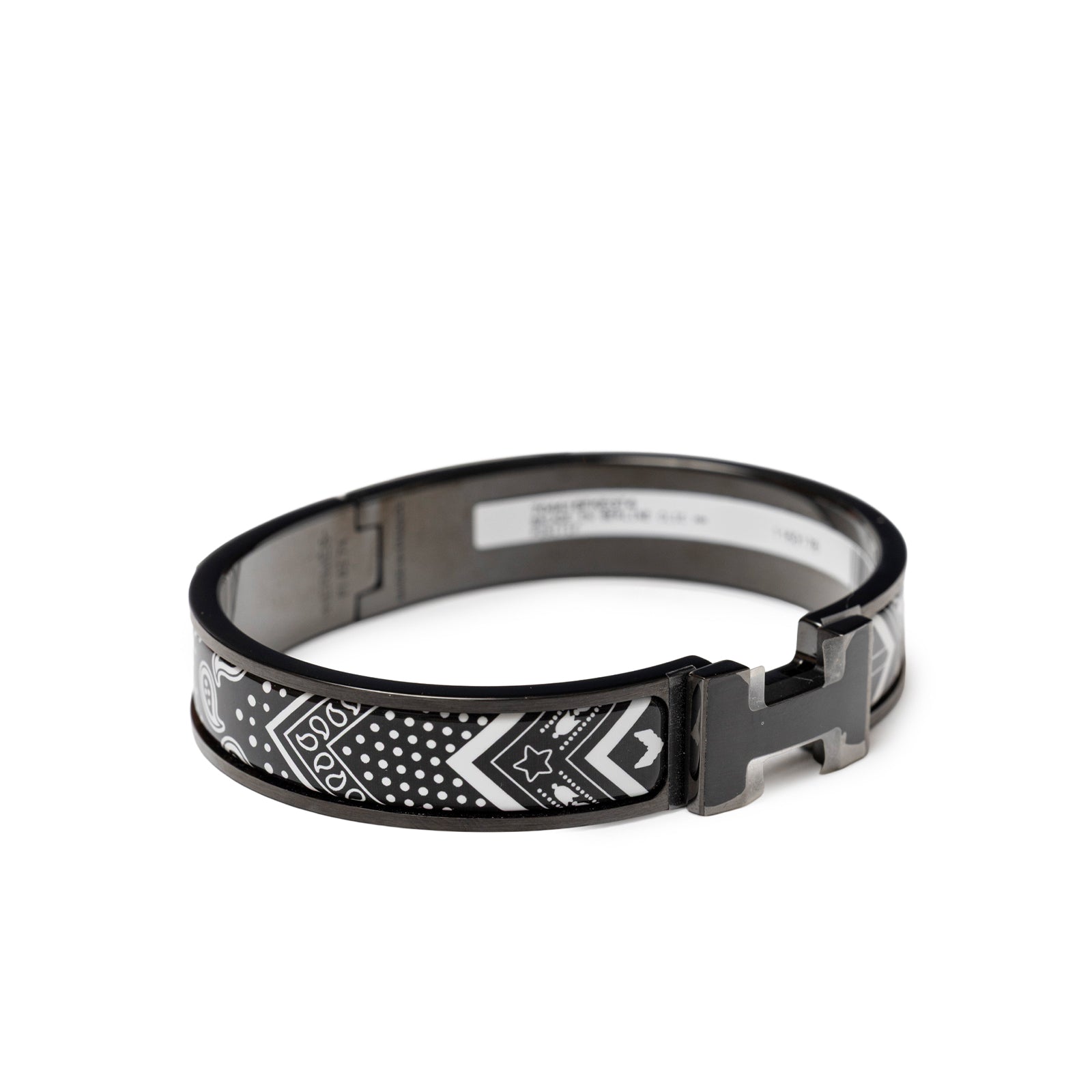 Angled front view of Hermès Clic HH Bandana So Black Bracelet Positif with black and white pattern and silver clasp