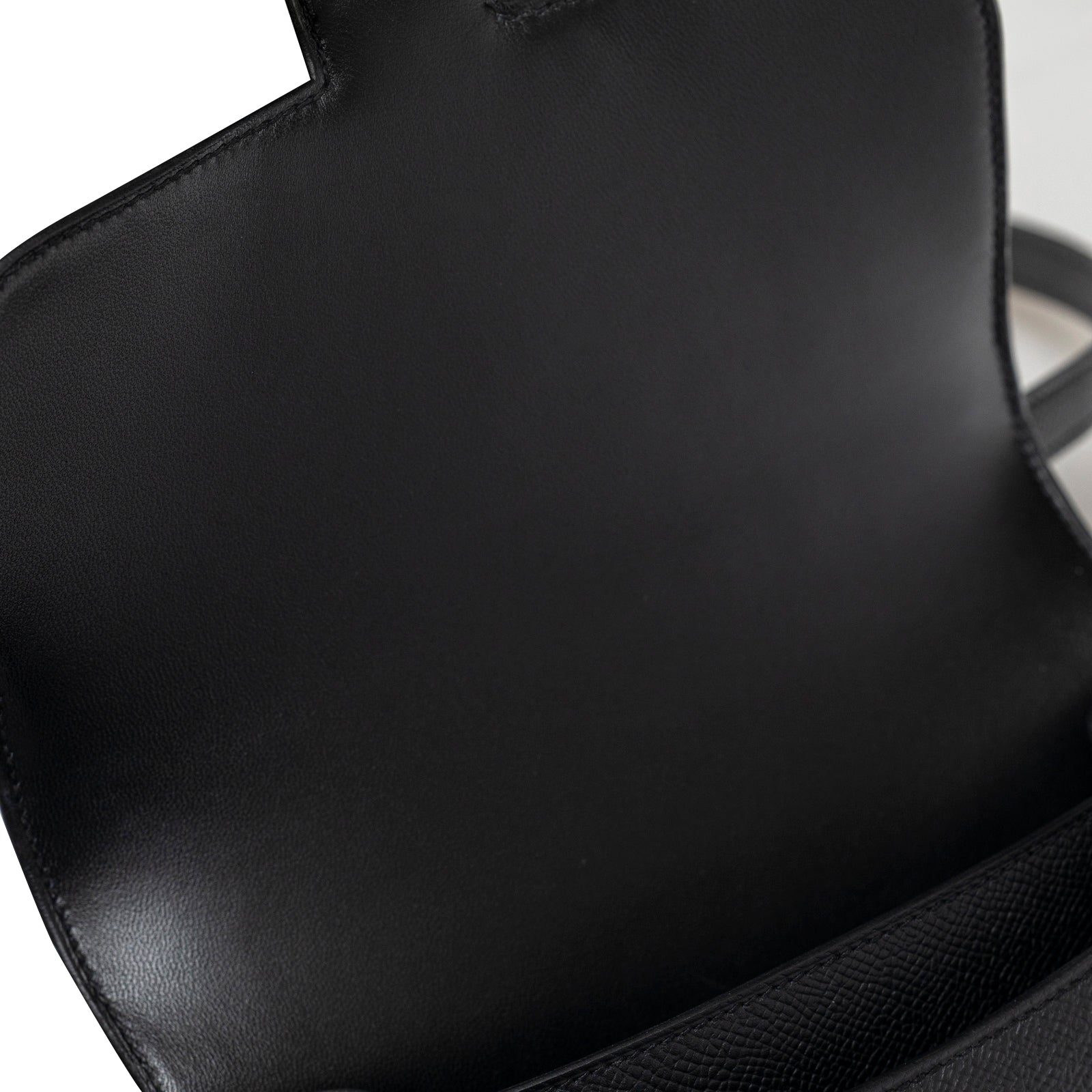 Close-up interior view of Hermès Constance 18 Black Epsom Gold Hardware showing smooth black leather lining and stitching details.