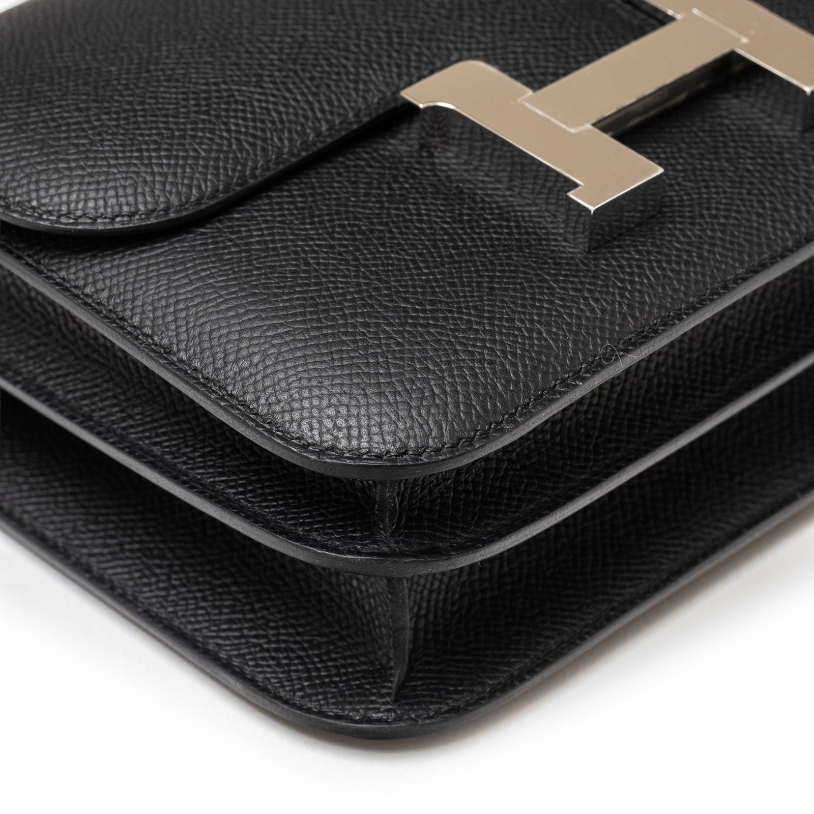 Close-up angled shot of Hermès Constance 18 Black Epsom Palladium Hardware focusing on leather texture and stitching detail