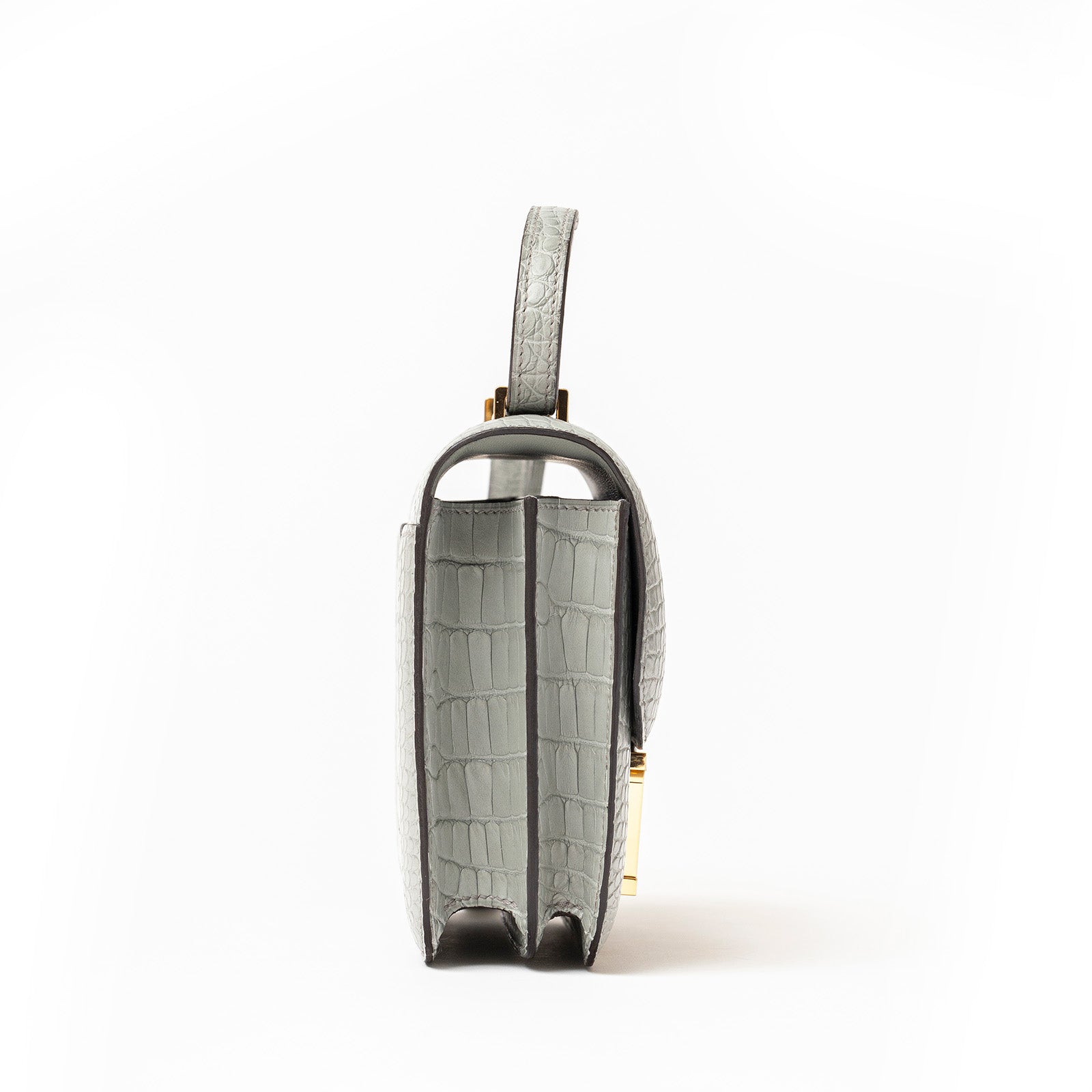 Side profile of Hermès Mini Constance 18 Gris Ciment Matte Alligator Gold Hardware showing texture and compartments