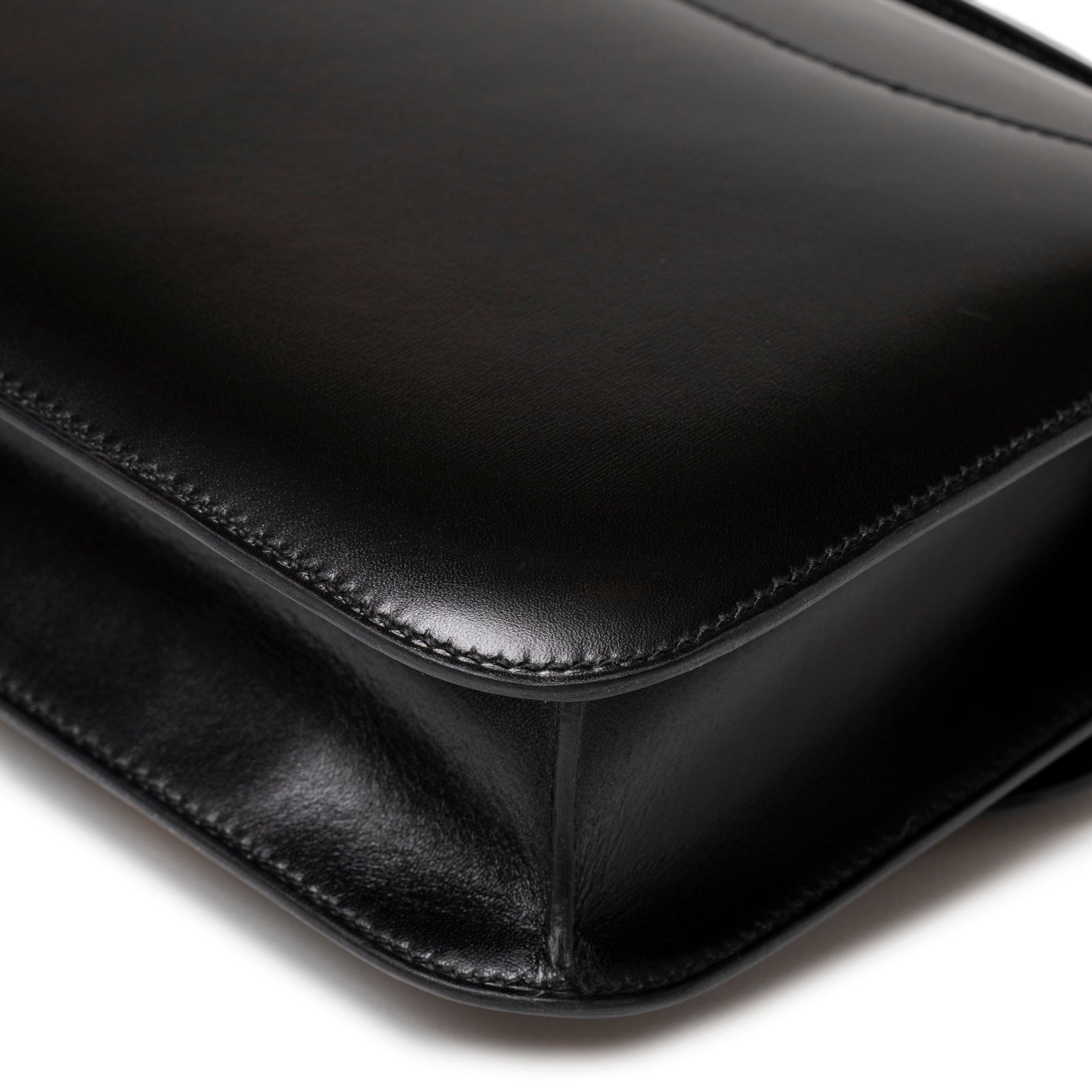 Close-up of smooth black leather corner and stitching on Hermès Constance 24 Black Box Gold Hardware handbag