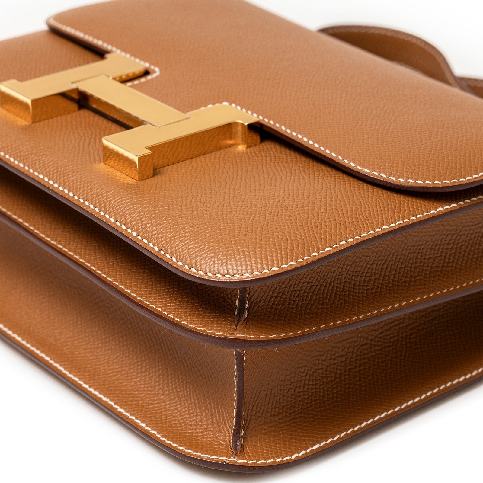 Close-up angled shot of Hermès Constance 24 Gold Epsom Gold Hardware showing textured leather and stitching detail
