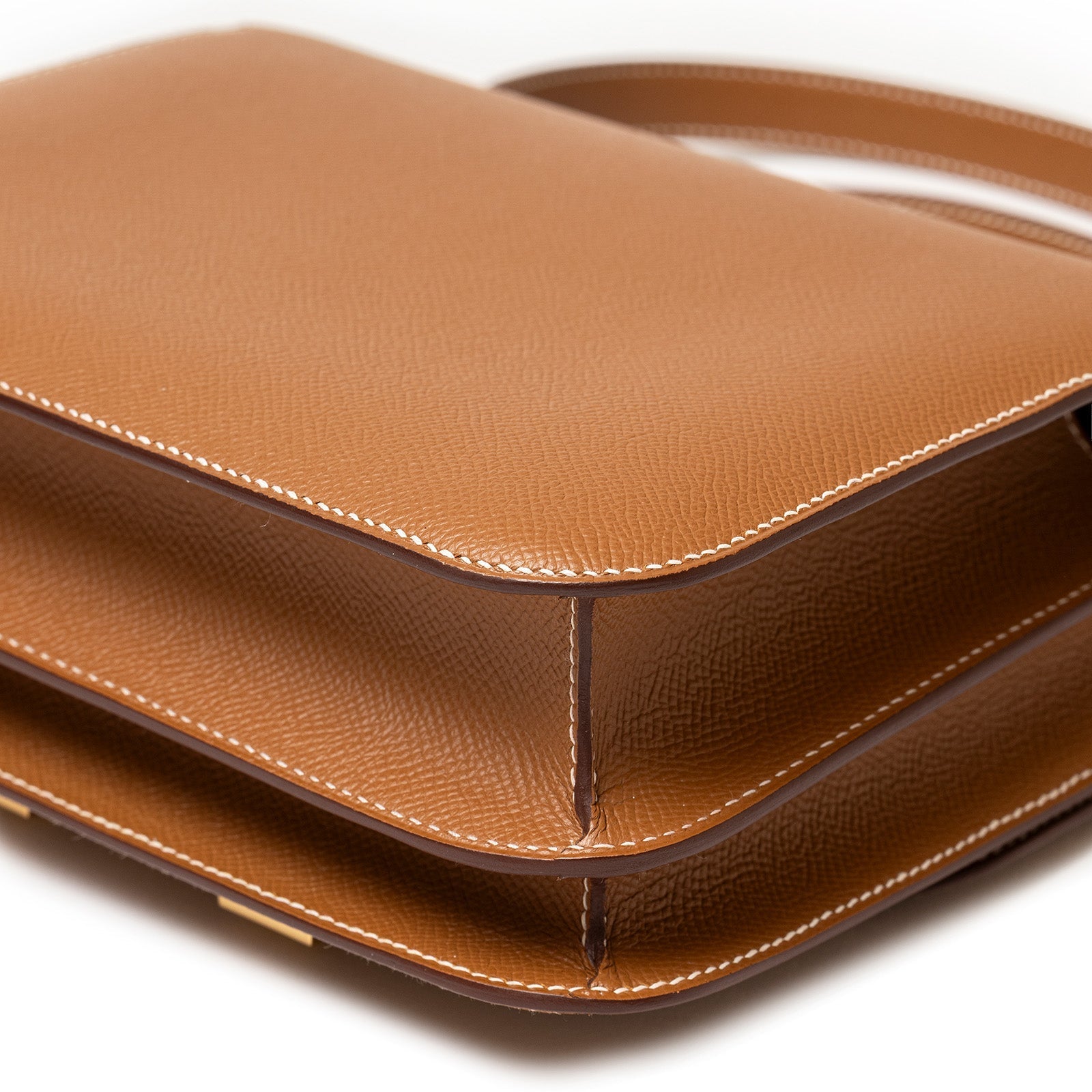 Close-up angled shot of Hermès Constance 24 Gold Epsom Gold Hardware showing texture and stitching detail