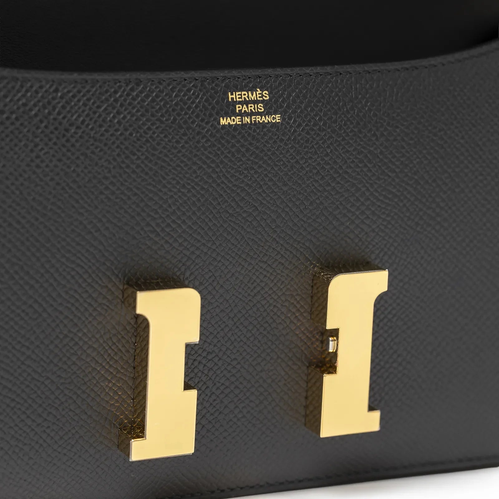 Close-up of Hermès Constance Elan Black Epsom Gold Hardware showing textured leather and gold clasp detail