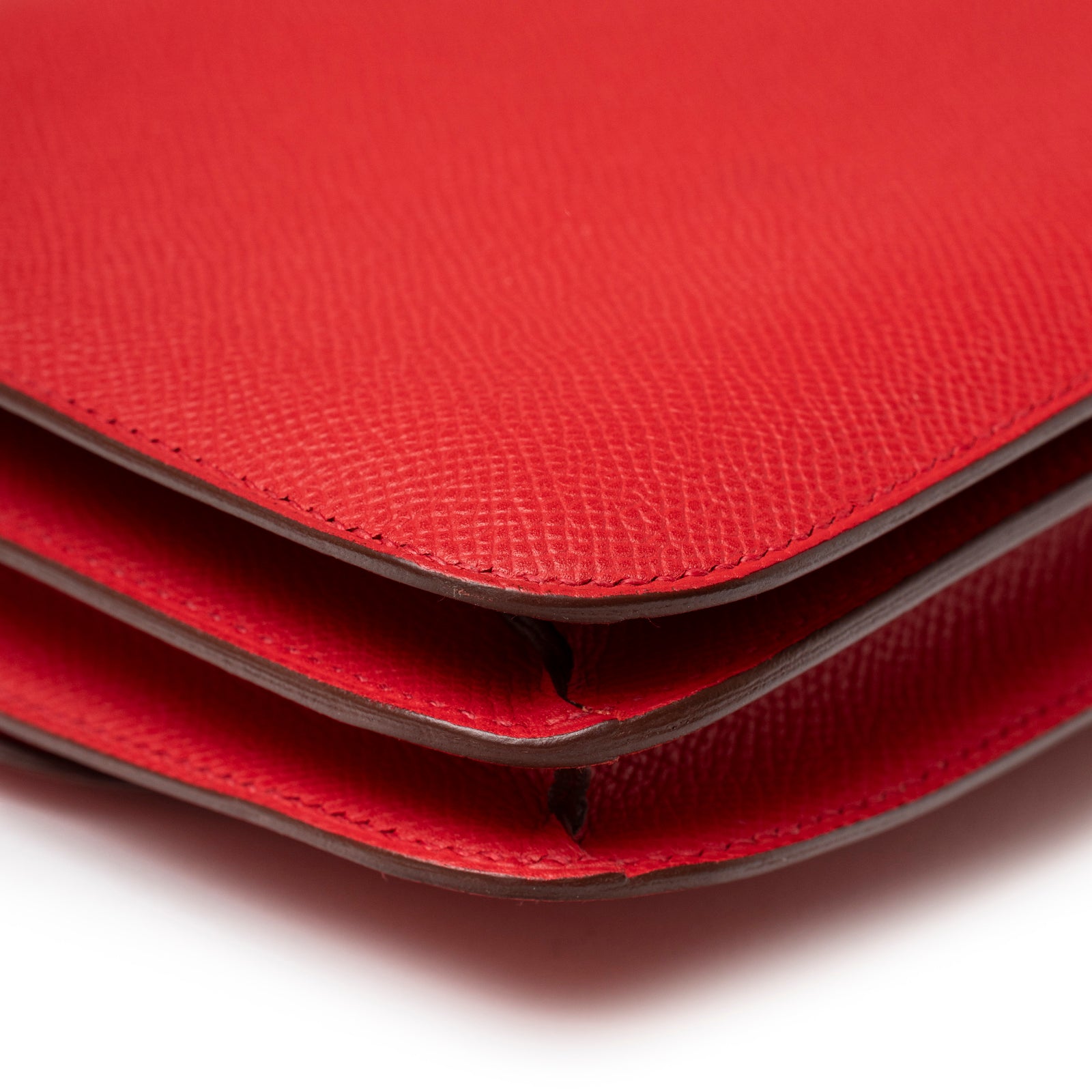 Close-up of folded edges and textured red leather on Hermès Constance Elan Rouge Epsom Palladium Hardware purse
