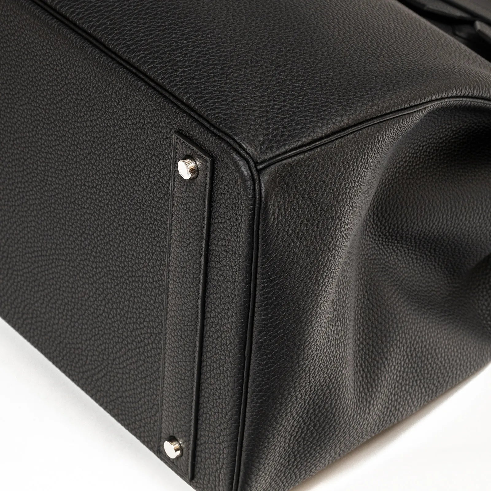 Close-up of Hermès Hac Birkin 40 Black Togo leather bottom corner with palladium hardware feet.