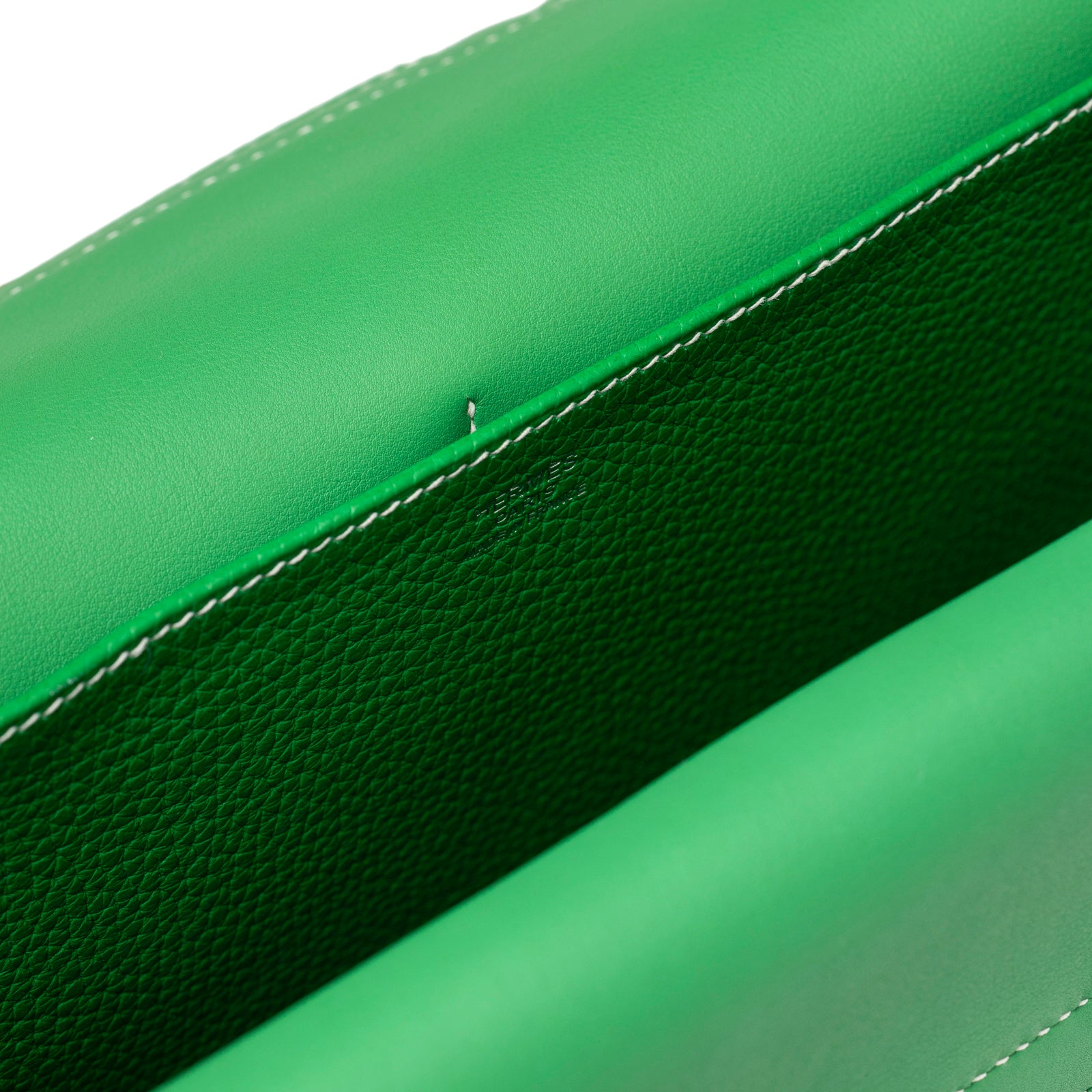 Close-up of vibrant green leather interior and white stitching detail on Hermès Halzan 31 Bambou Clemence Palladium Hardware