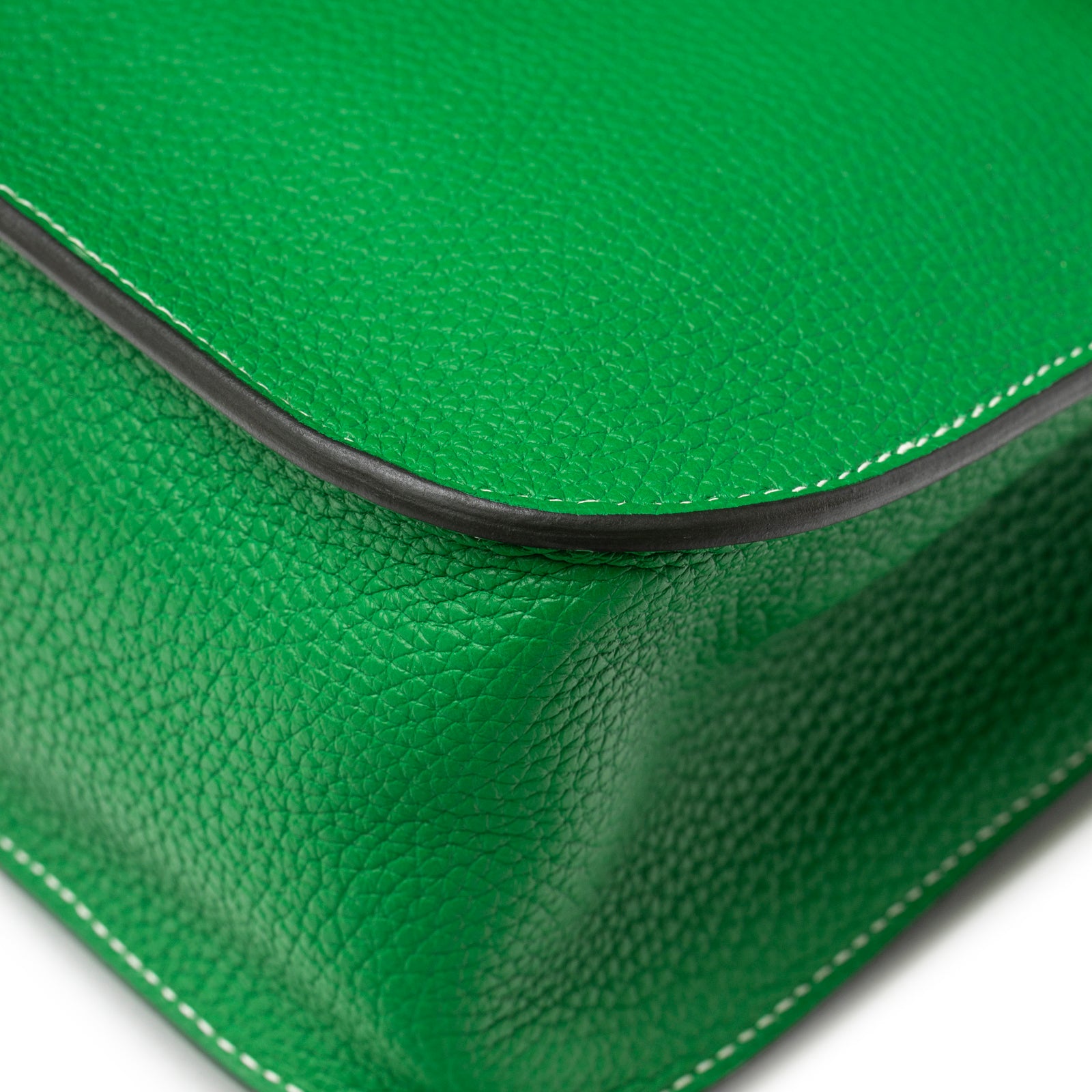 Close-up of corner showing vibrant green pebbled leather and white stitching on Hermès Halzan 31 Bambou Clemence Palladium Hardware
