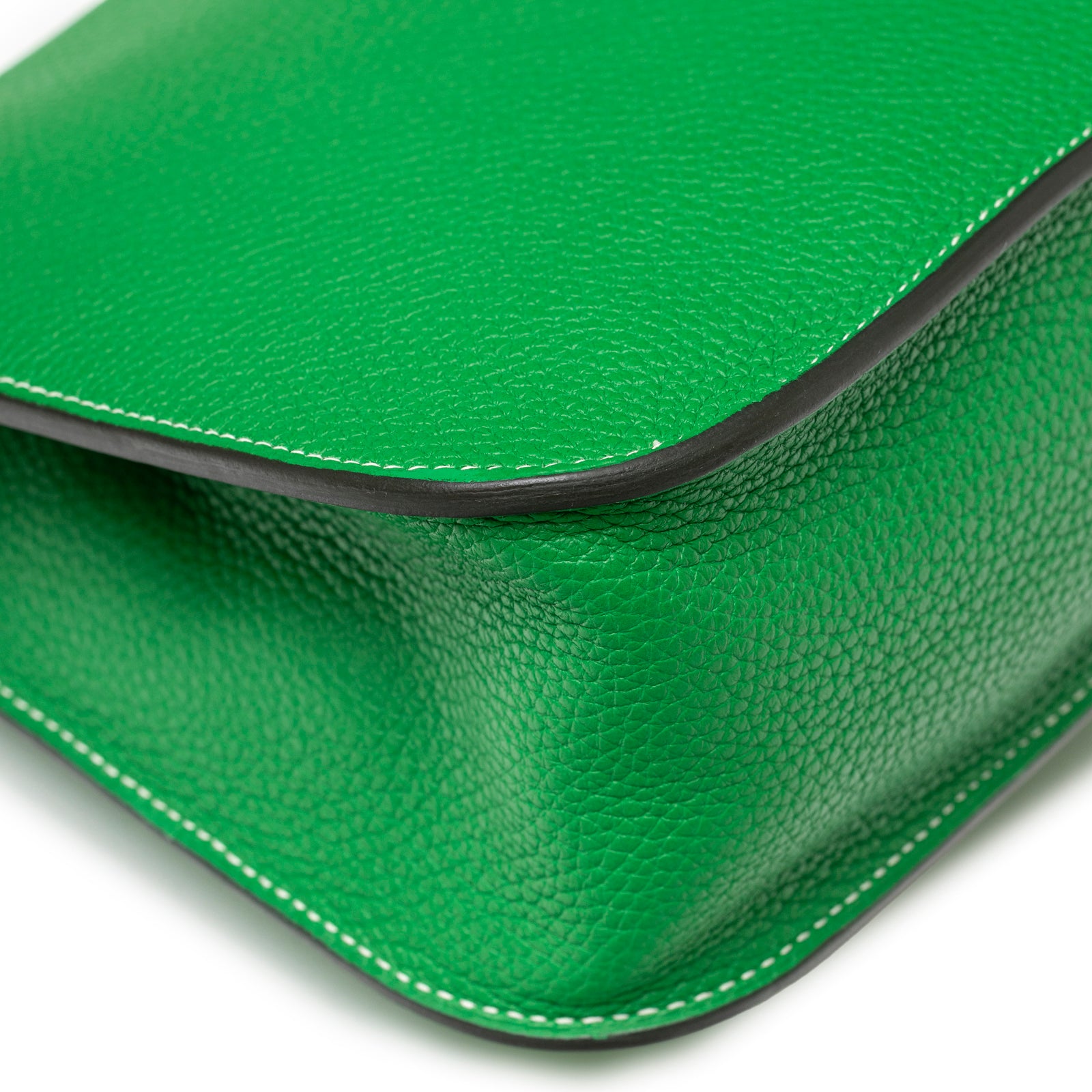 Close-up of vibrant green pebbled leather corner and white stitching on Hermès Halzan 31 Bambou Clemence Palladium Hardware