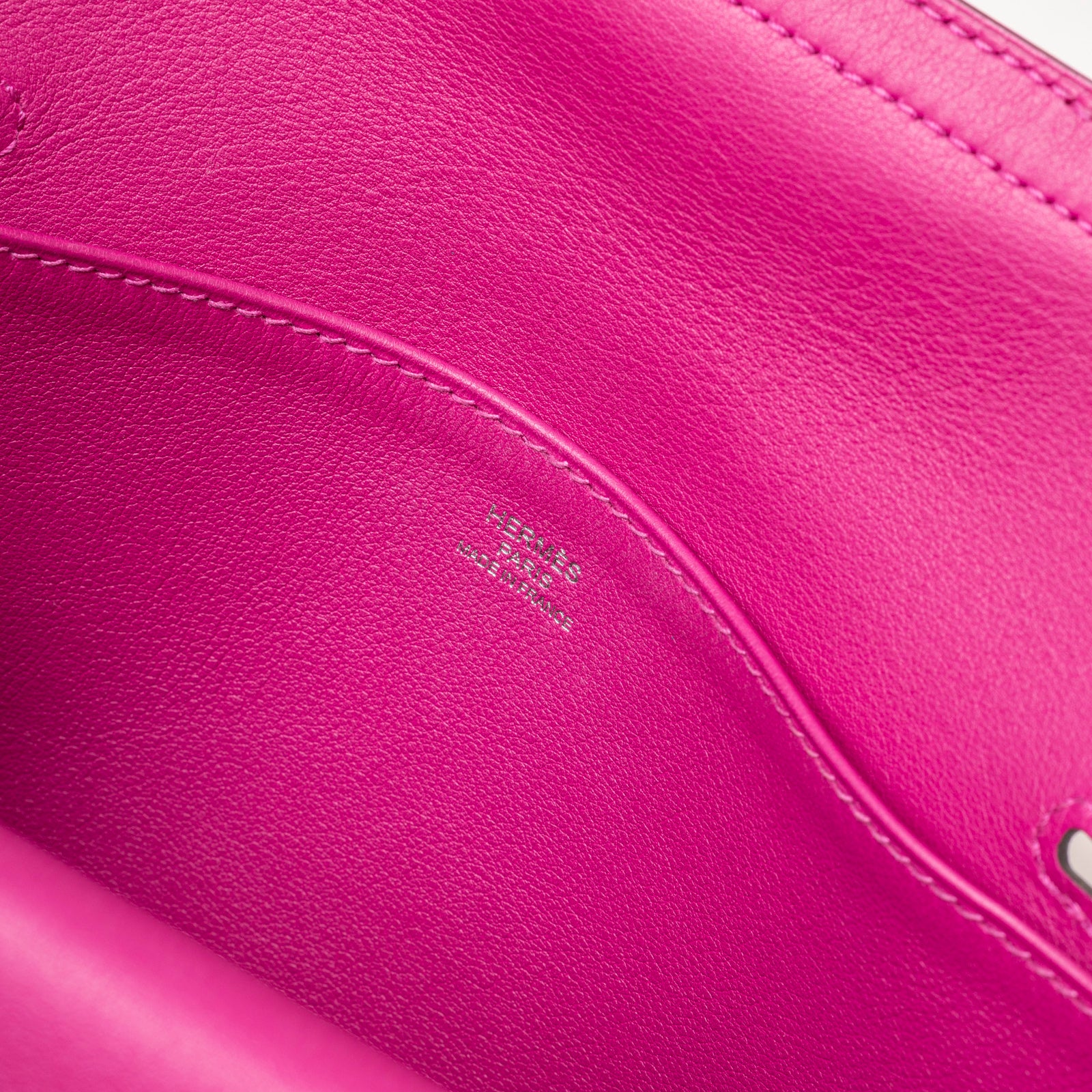 Close-up of Hermès Halzan Mini Rose Pourpre Swift Palladium Hardware interior showing leather texture and logo embossing