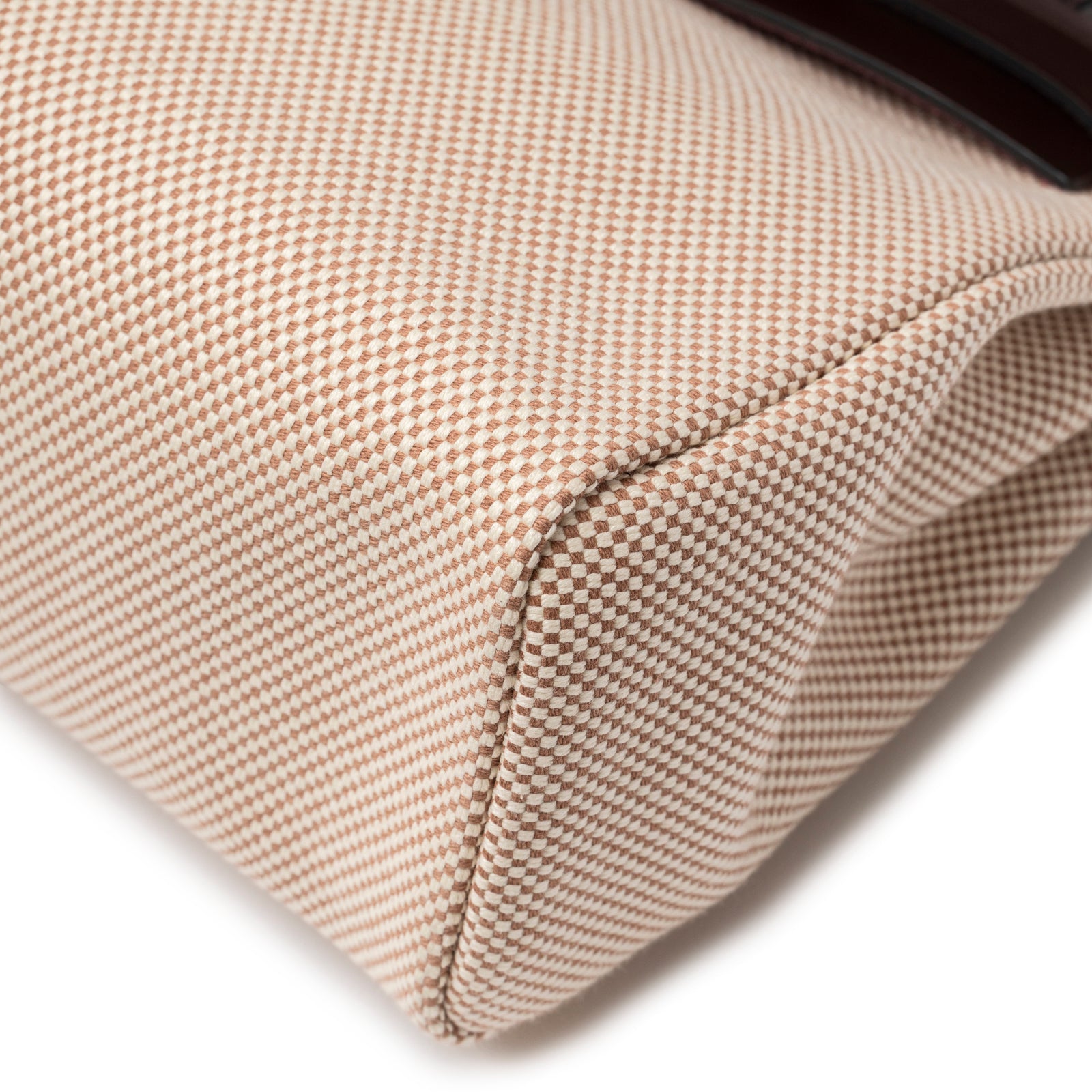 Close-up of bottom corner showcasing textured beige and ecru canvas on Hermès Herbag Zip PM 31 Ecru and Beige Toile H Ebene Hunter Gold Hardware