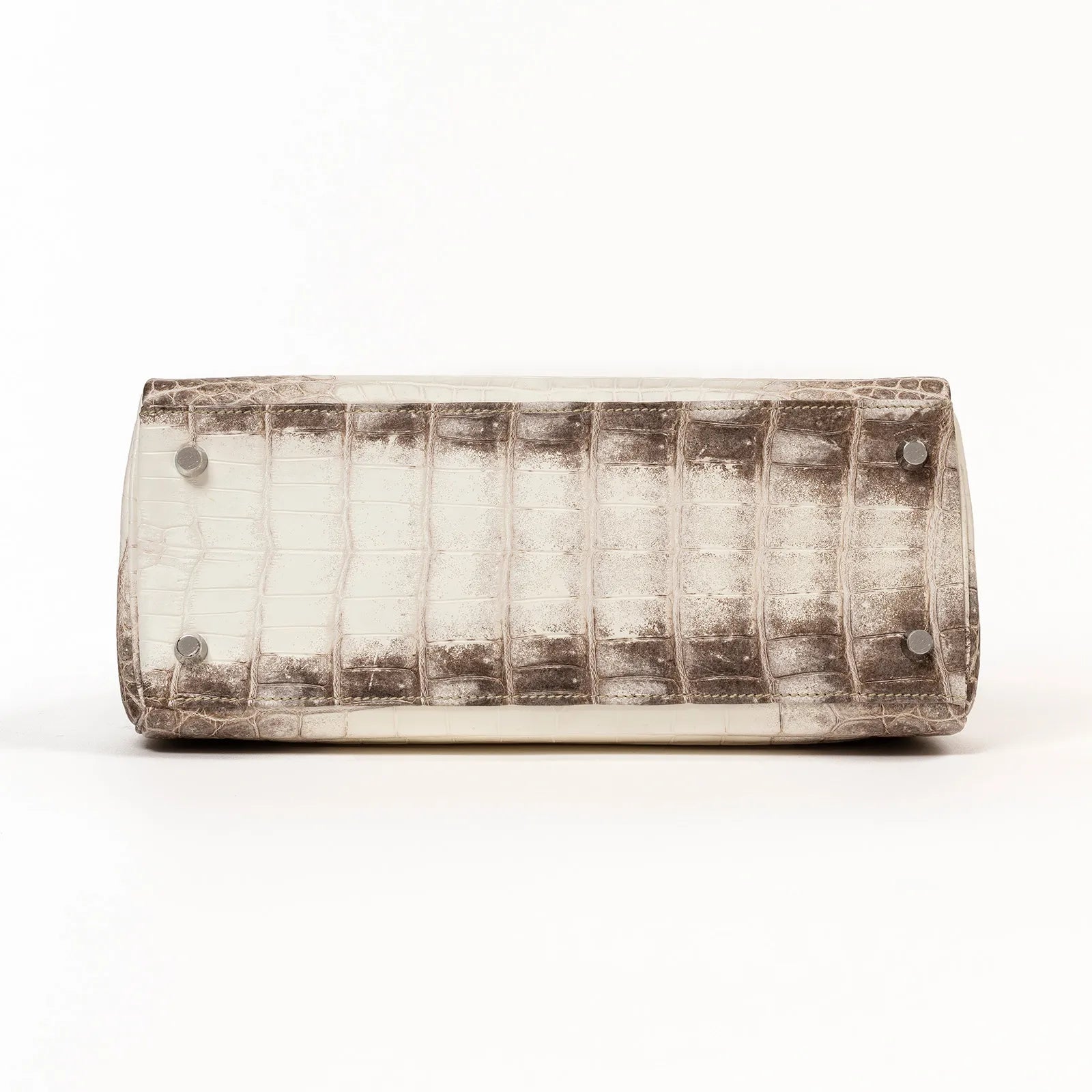 Bottom view of a Hermès Himalaya Kelly 28 Retourne Blanc Matte Niloticus Crocodile Palladium Hardware on a white background.