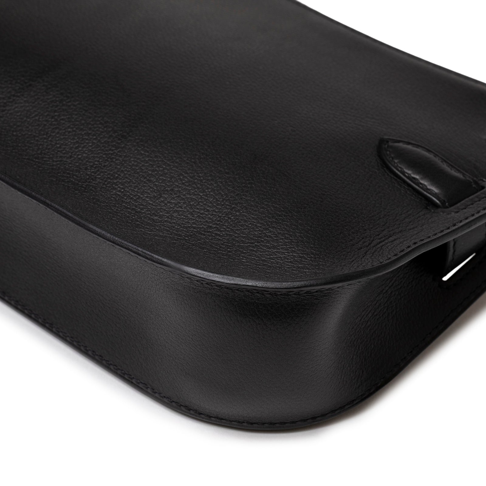 Close-up angled view of smooth leather base and craftsmanship on Hermès Jypsiere Mini Black Evergrain Gold Hardware handbag