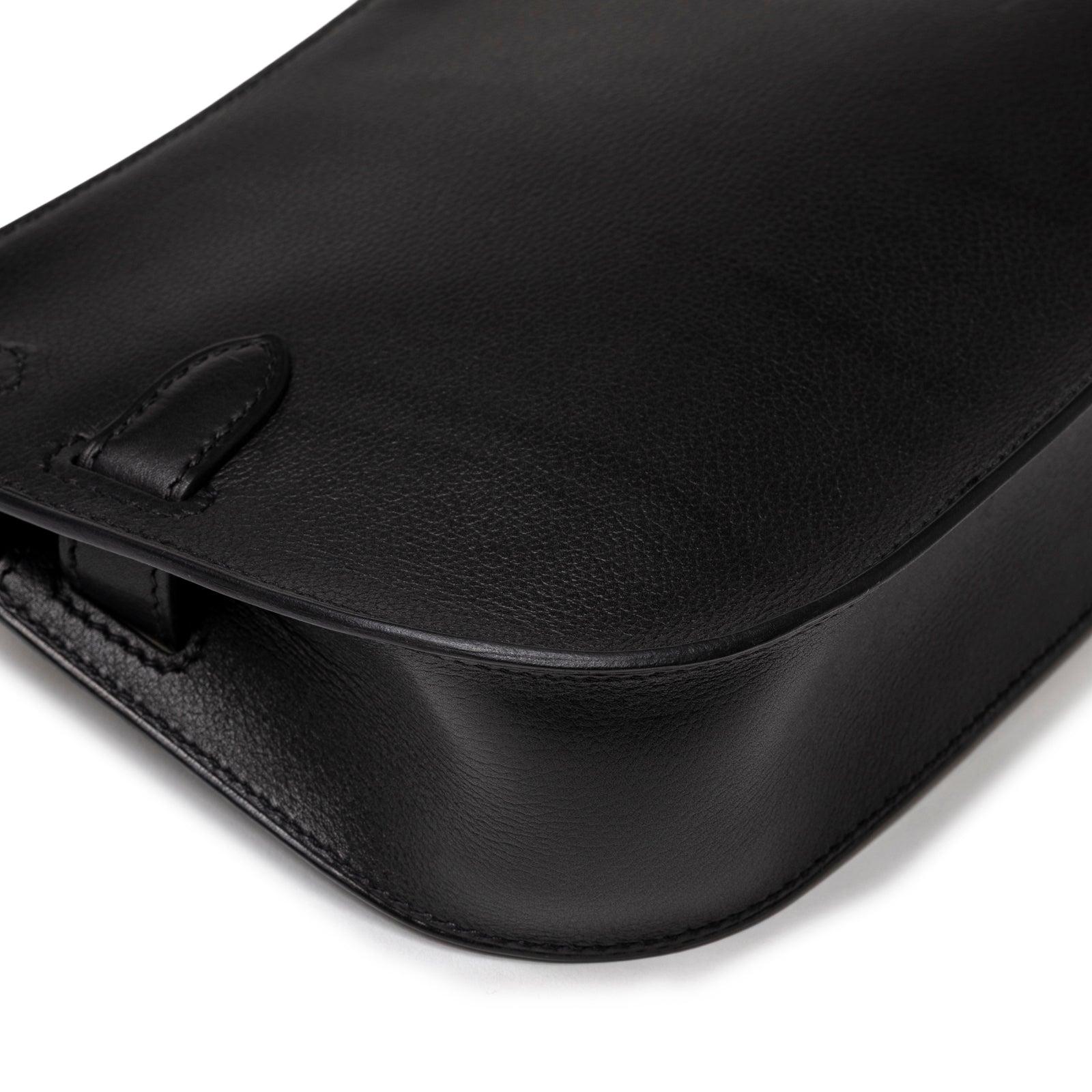Close-up angled detail of smooth black leather and fine stitching on Hermès Jypsiere Mini Black Evergrain Gold Hardware