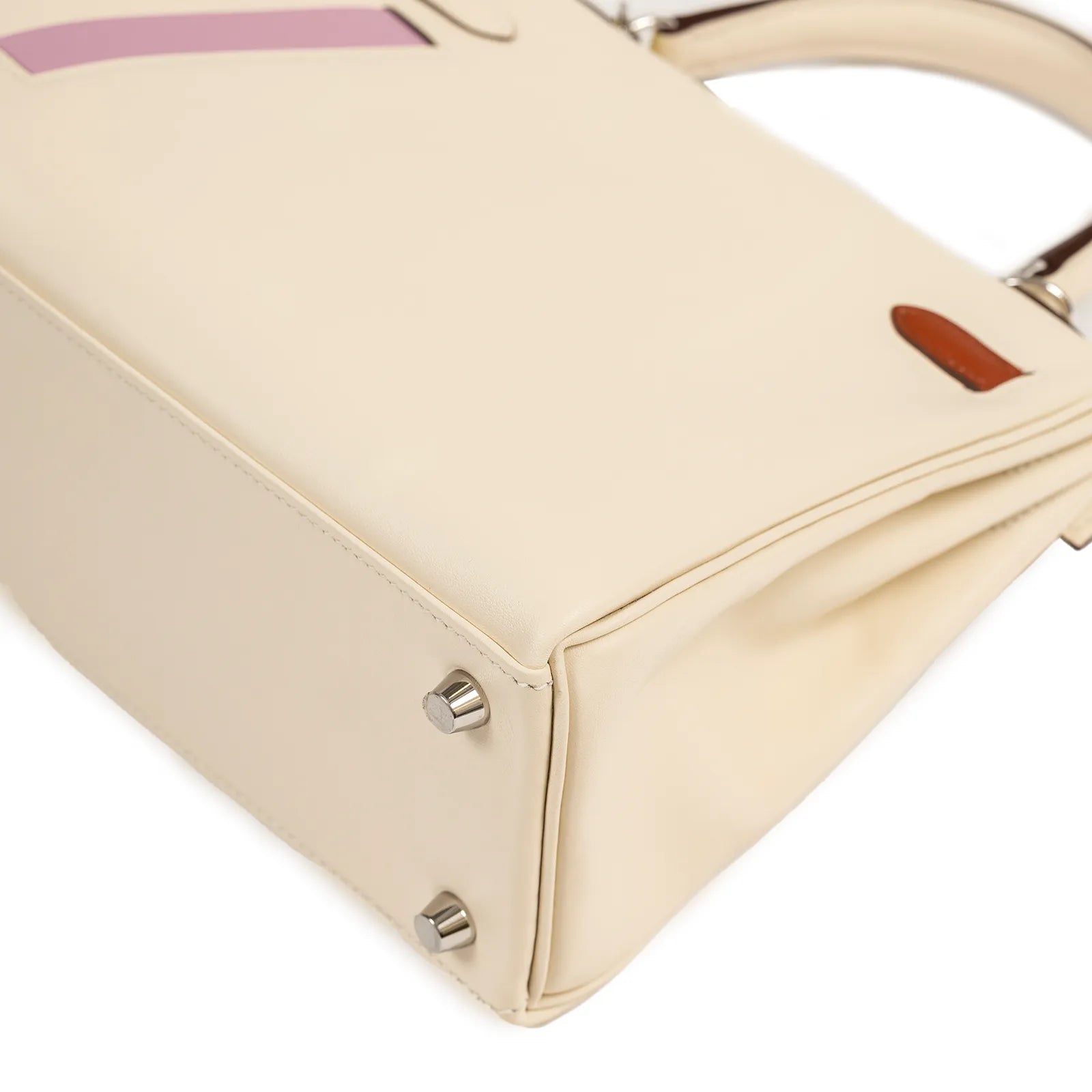 Close-up angled view of the bottom corner showing smooth nata leather and palladium hardware feet on the bag