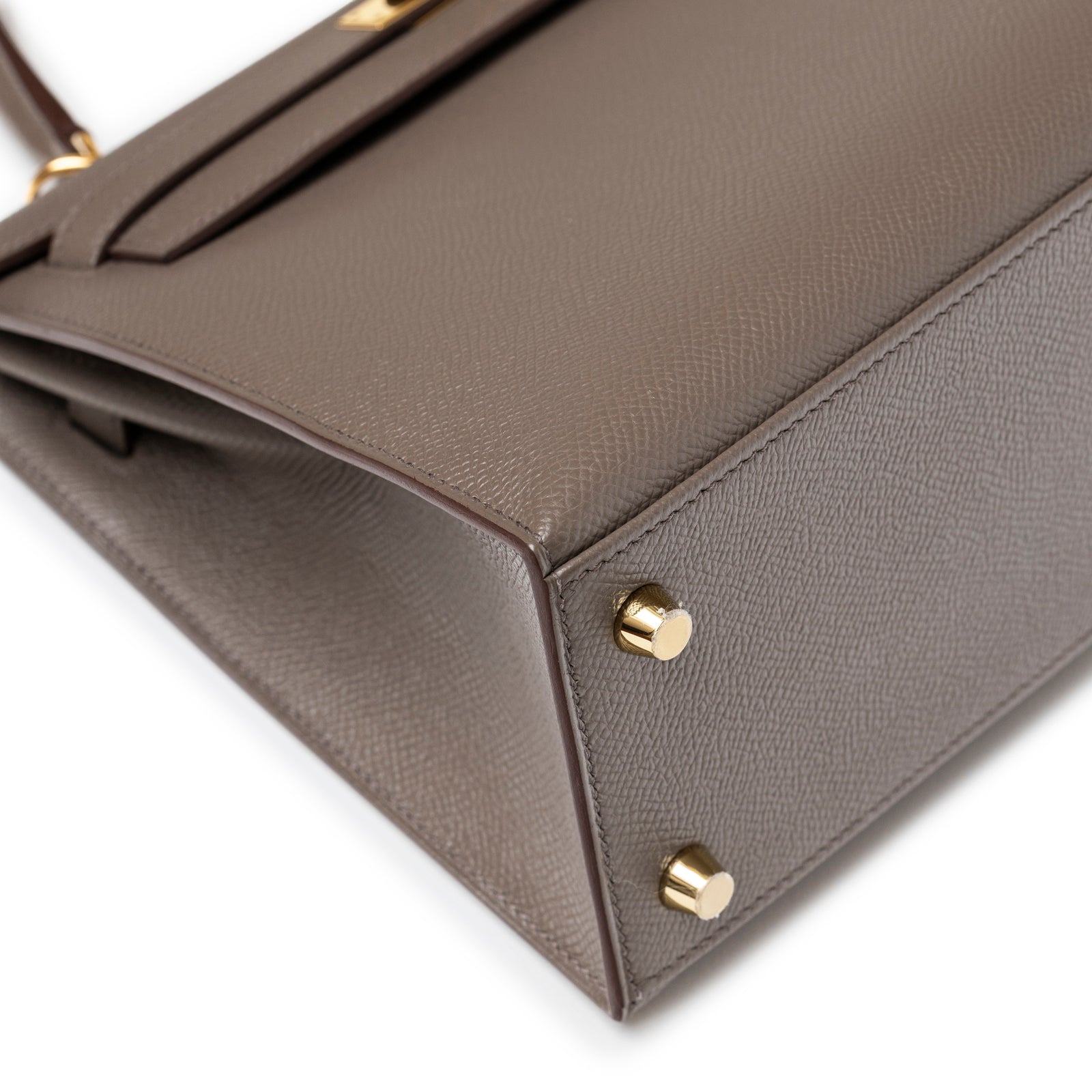 Close-up of Hermès Kelly 25 Sellier Etain Epsom Gold Hardware showing textured leather and gold protective feet detail