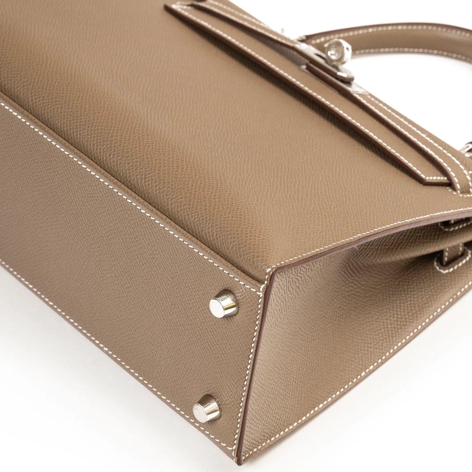 Hermès Kelly 25 Sellier Etoupe Epsom Palladium Hardware handbag with metal studs and stitching detail on a white background.
