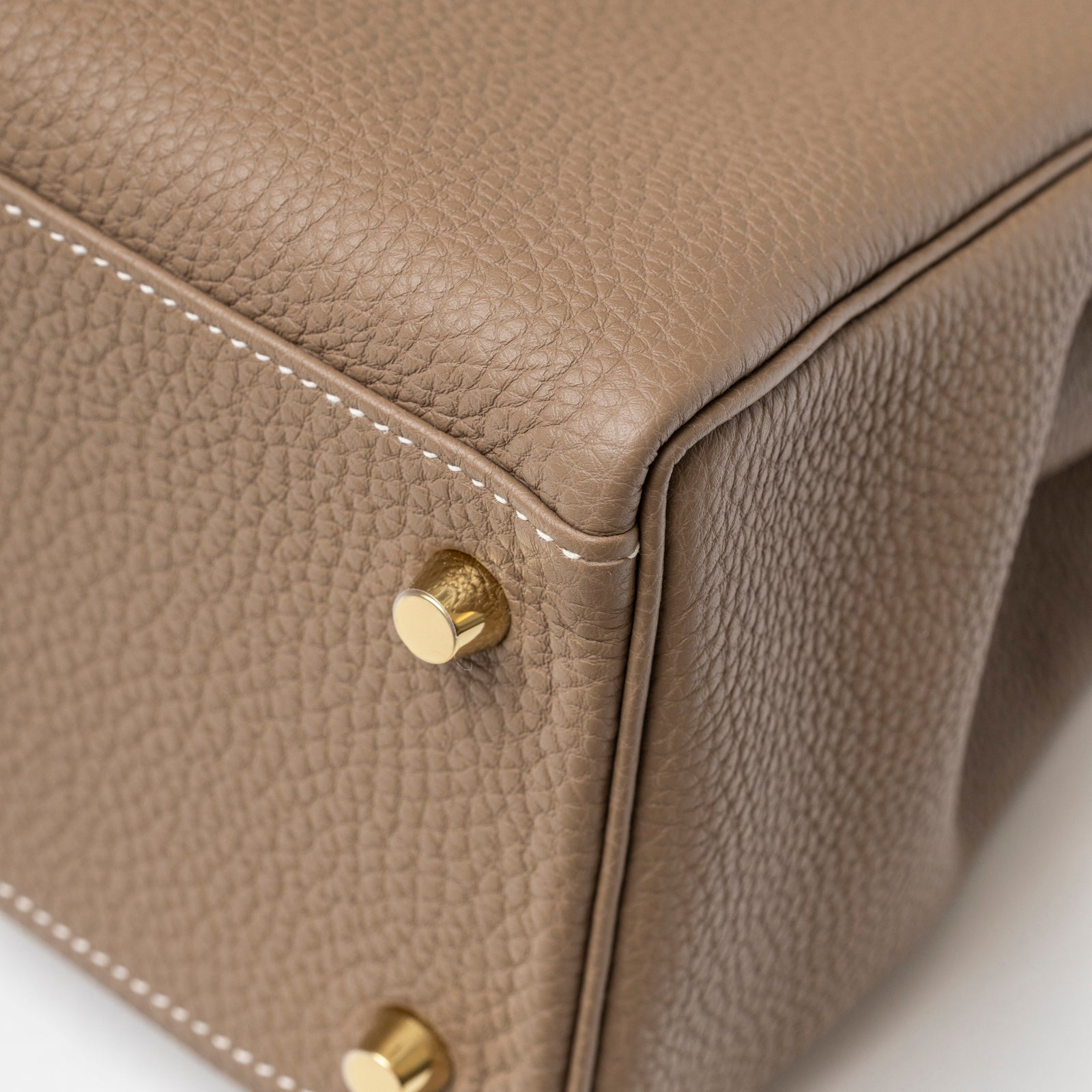 Close-up of Hermès Kelly 28 Retourne Etoupe Togo Gold Hardware corner showing gold protective feet and textured leather