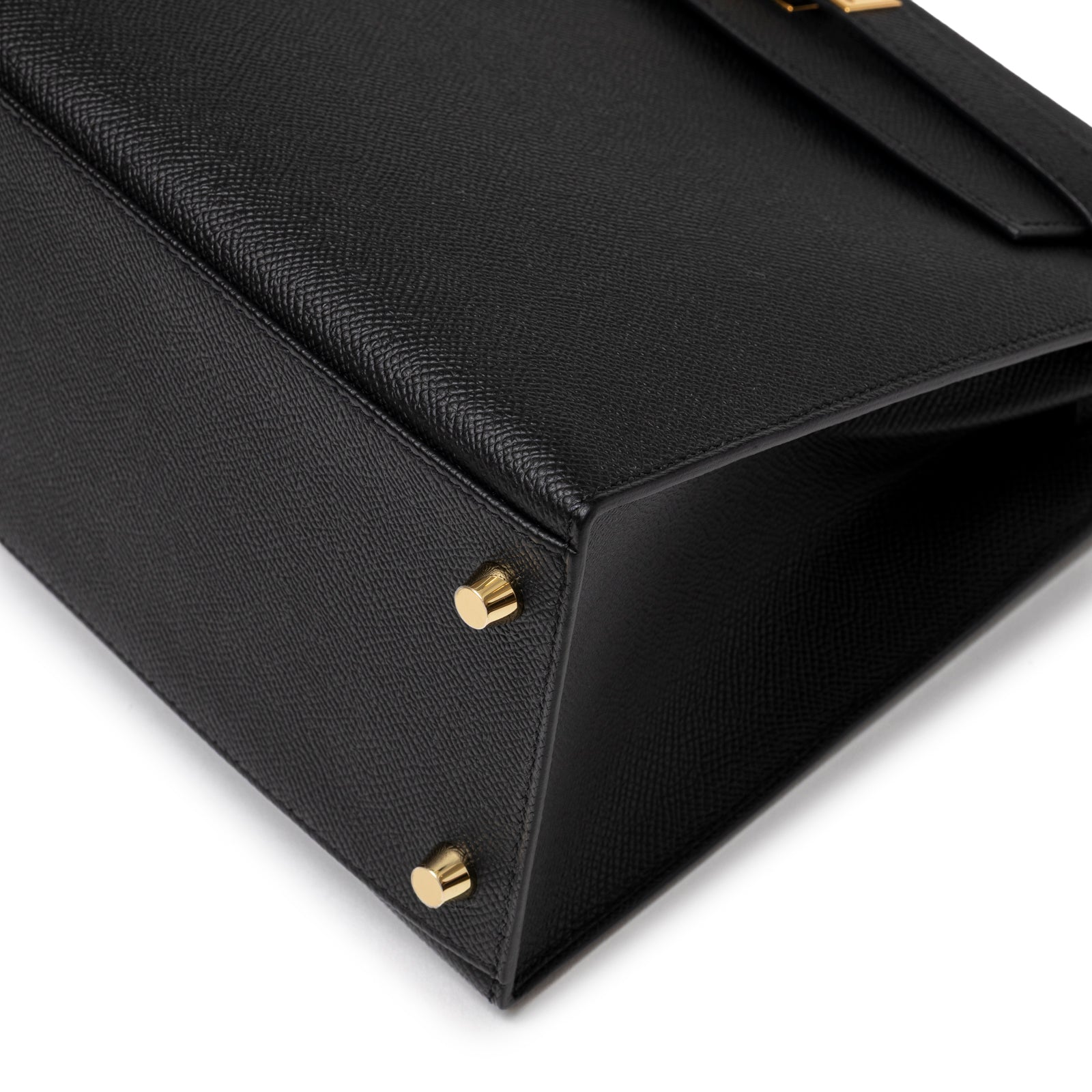 Close-up of bottom corner on Hermès Kelly 28 Sellier Black Epsom Gold Hardware showing textured leather and gold feet