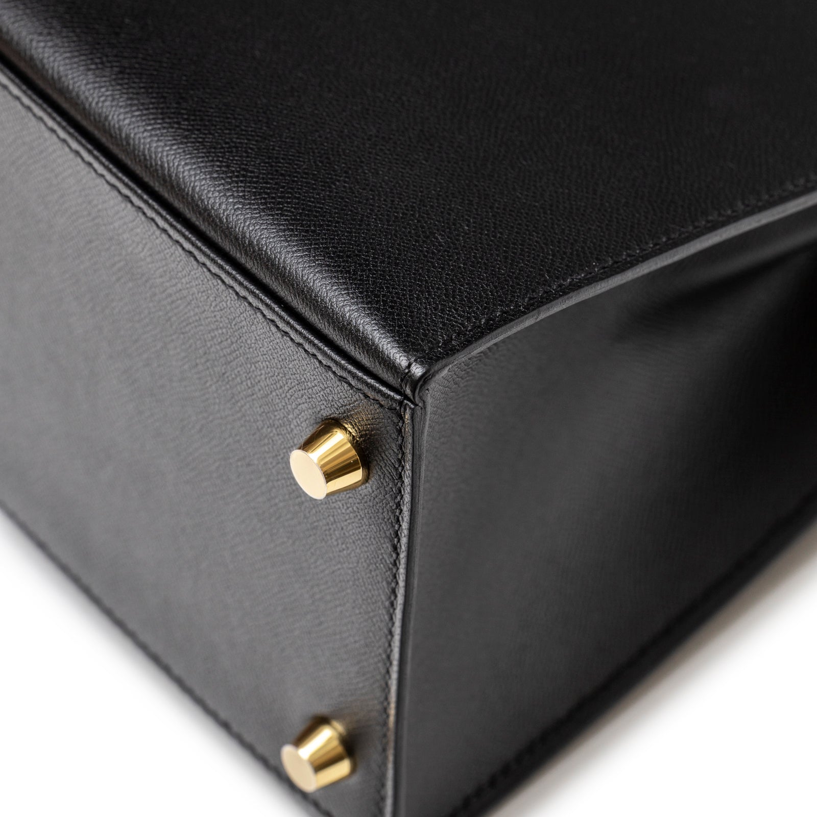 Close-up of Hermès Kelly 28 Sellier Touch Black Madame Shiny Niloticus Crocodile Gold Hardware showing gold feet and textured leather corner detail