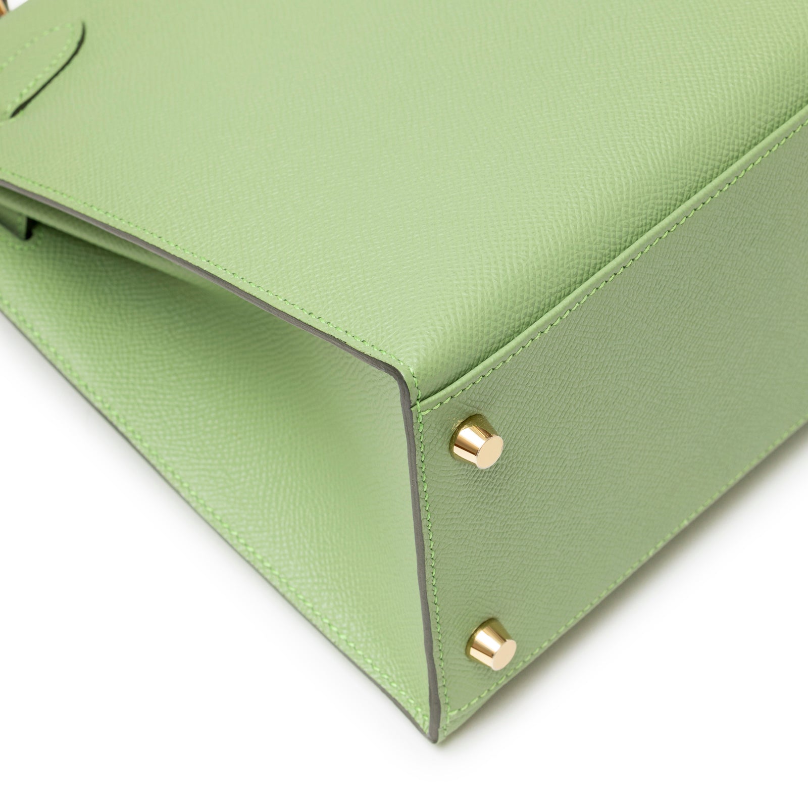 Bottom corner close-up showing light green Epsom leather and gold feet on Hermès Kelly 28 Sellier Vert Criquet Epsom Gold Hardware