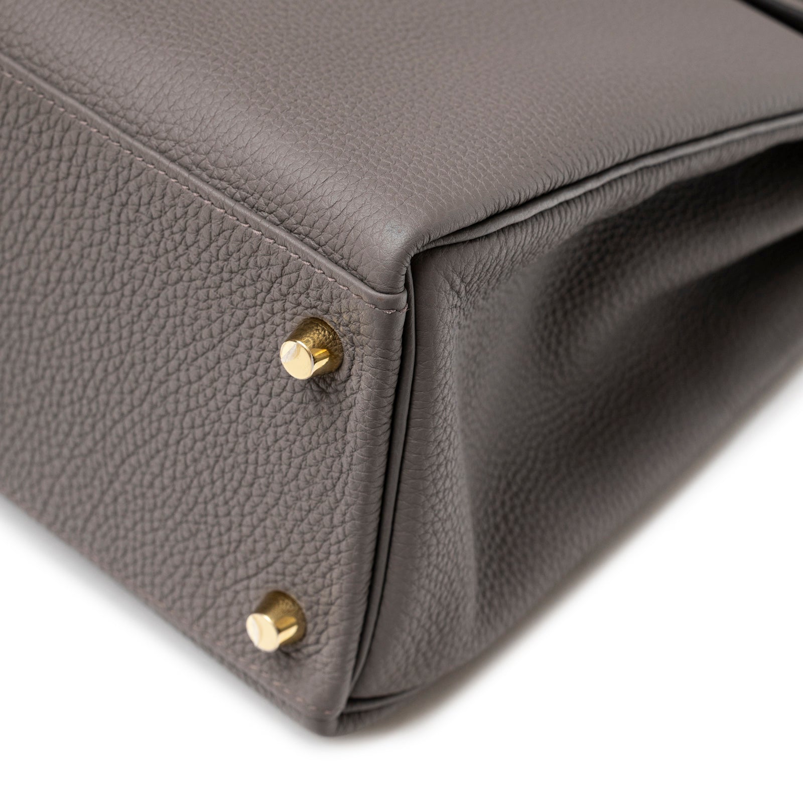 Close-up of the bottom corner with gold feet on Hermès Kelly 32 Retourne Etain Togo Gold Hardware handbag.