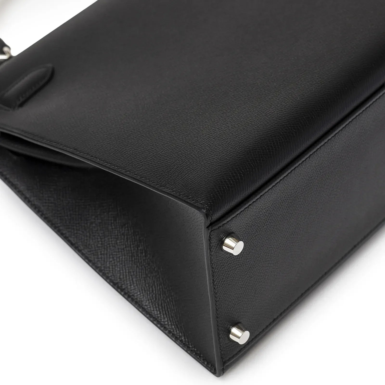 Close-up bottom and corner view of Hermès Kelly 32 Sellier Black Epsom Palladium Hardware showing texture and metal feet details