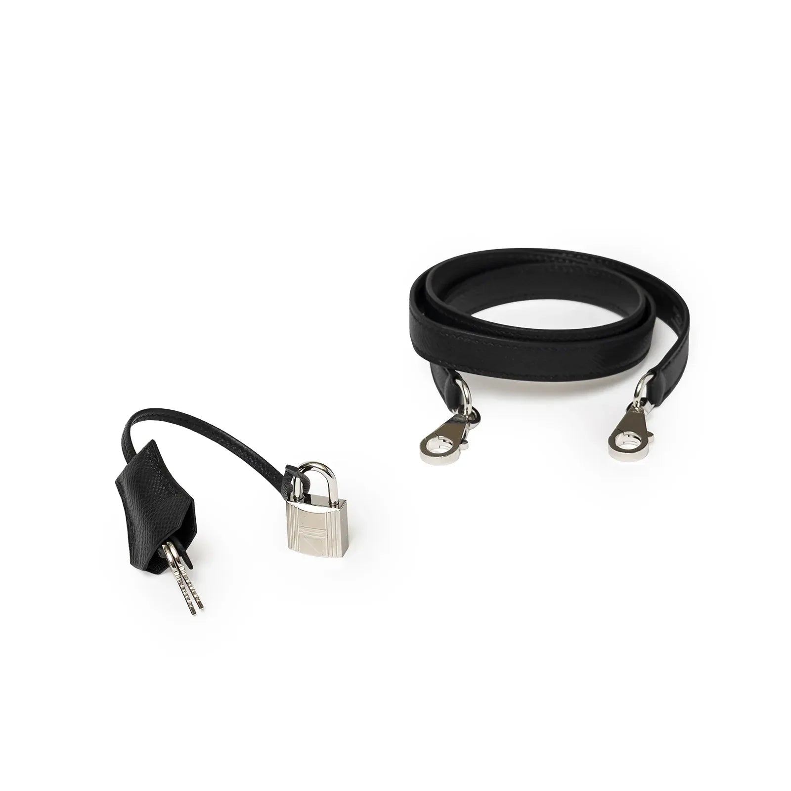 Close-up of Hermès Kelly 32 Sellier Black Epsom Palladium Hardware detachable strap and lock with keys on white background