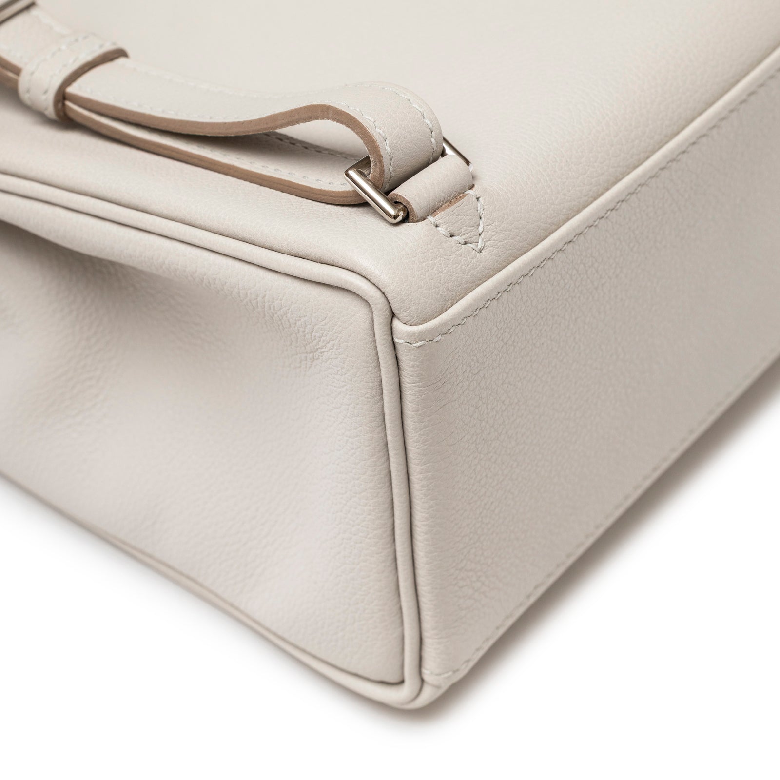 Close-up of smooth piping and leather texture at base corner on Hermès Kelly Ado Backpack Gris Perle Evercolor Palladium Hardware