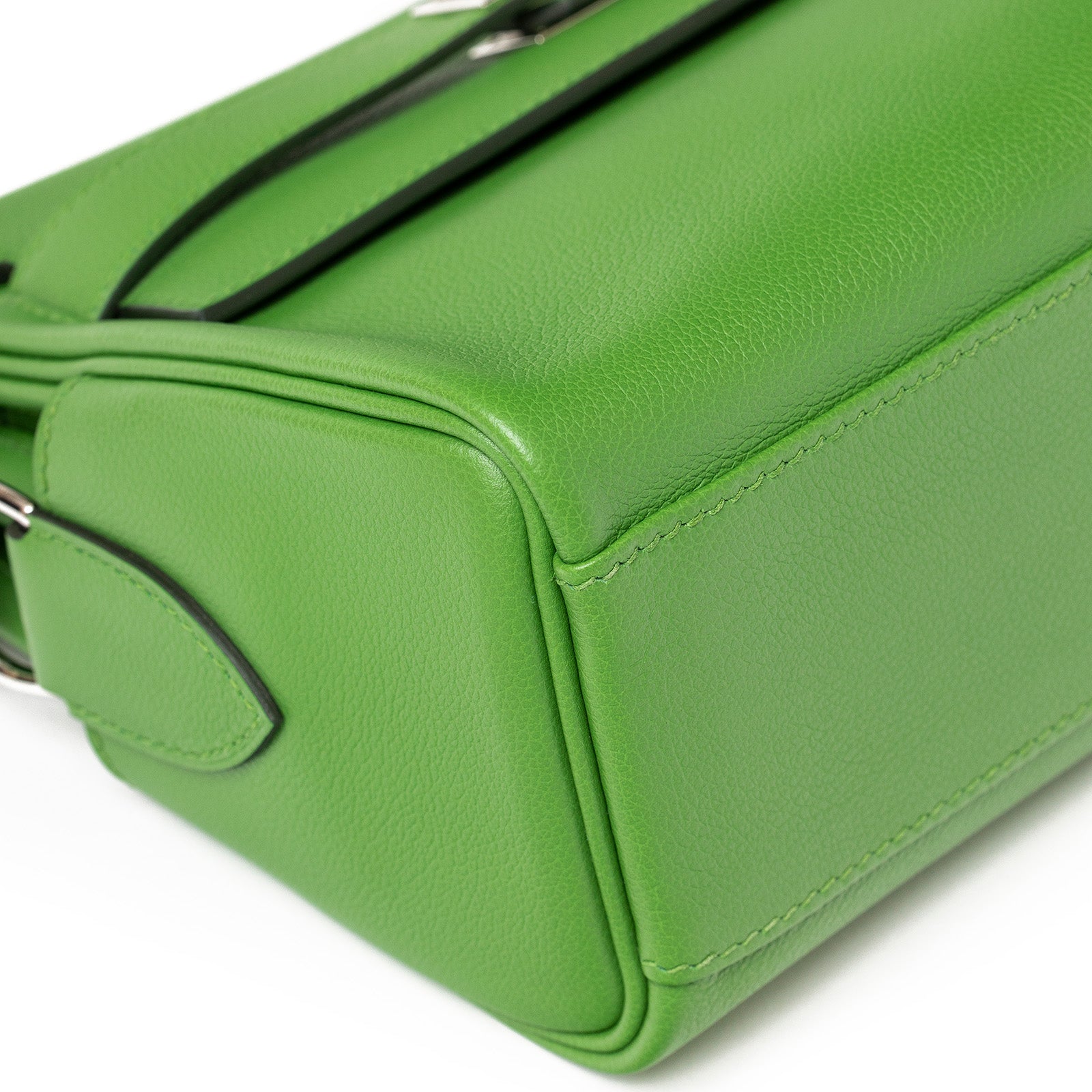 Angled side view of Hermès Kelly Messenger PM Vert Yucca Evercolor Palladium Hardware handbag with sleek black accents and fine stitching detail.