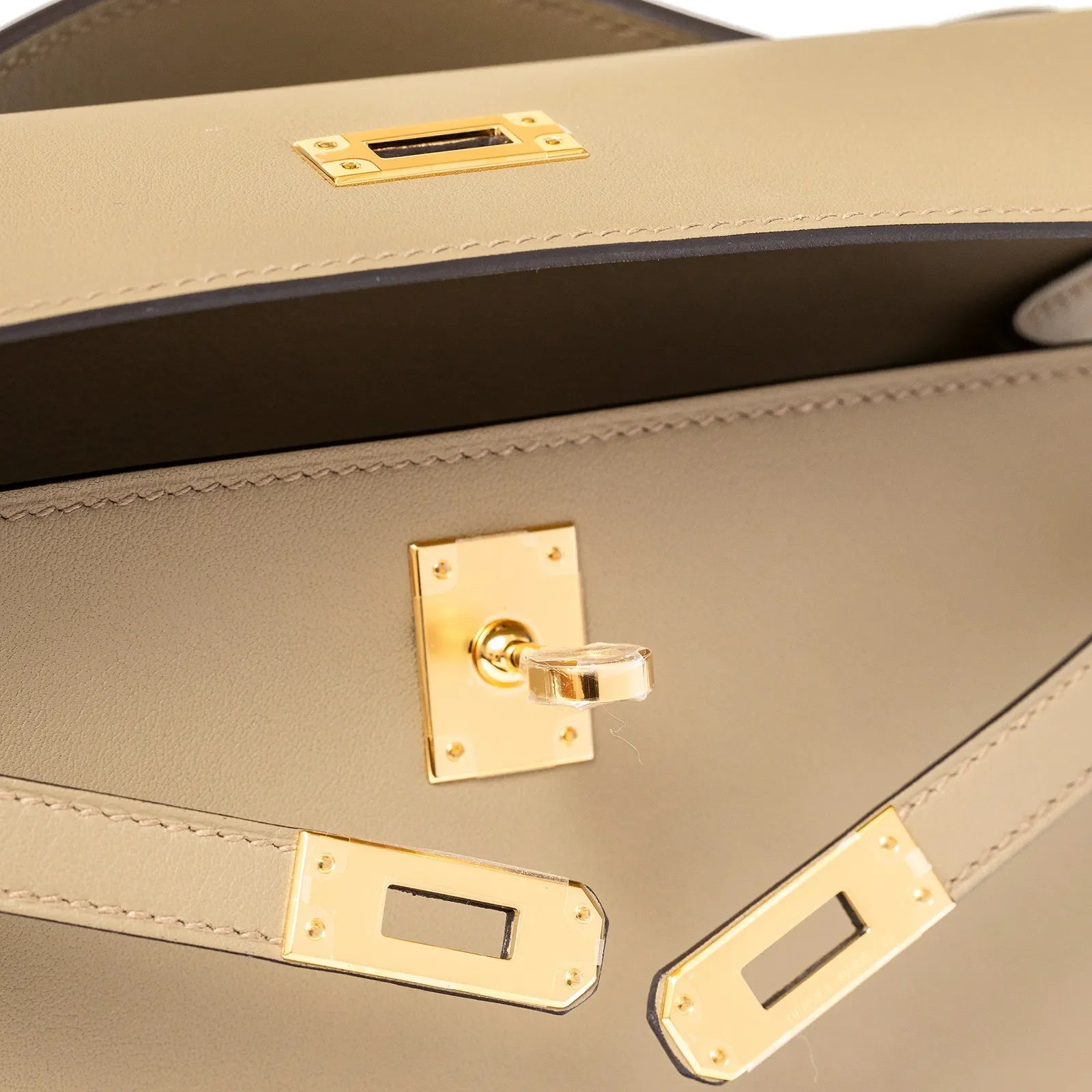 Close-up of the Hermès Kelly Pochette Beige Marfa Swift Gold Hardware showing detailed leather and clasp craftsmanship