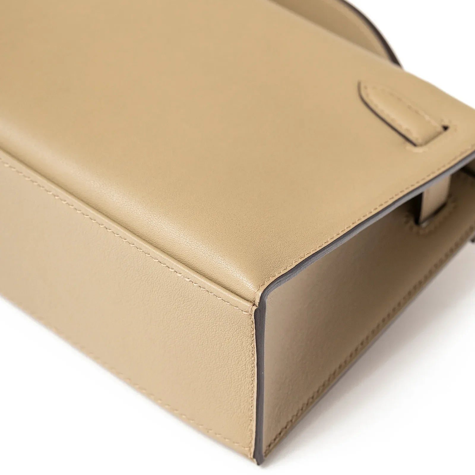 Close-up view of the finely crafted side detail of the Hermès Kelly Pochette Beige Marfa Swift Gold Hardware handbag.