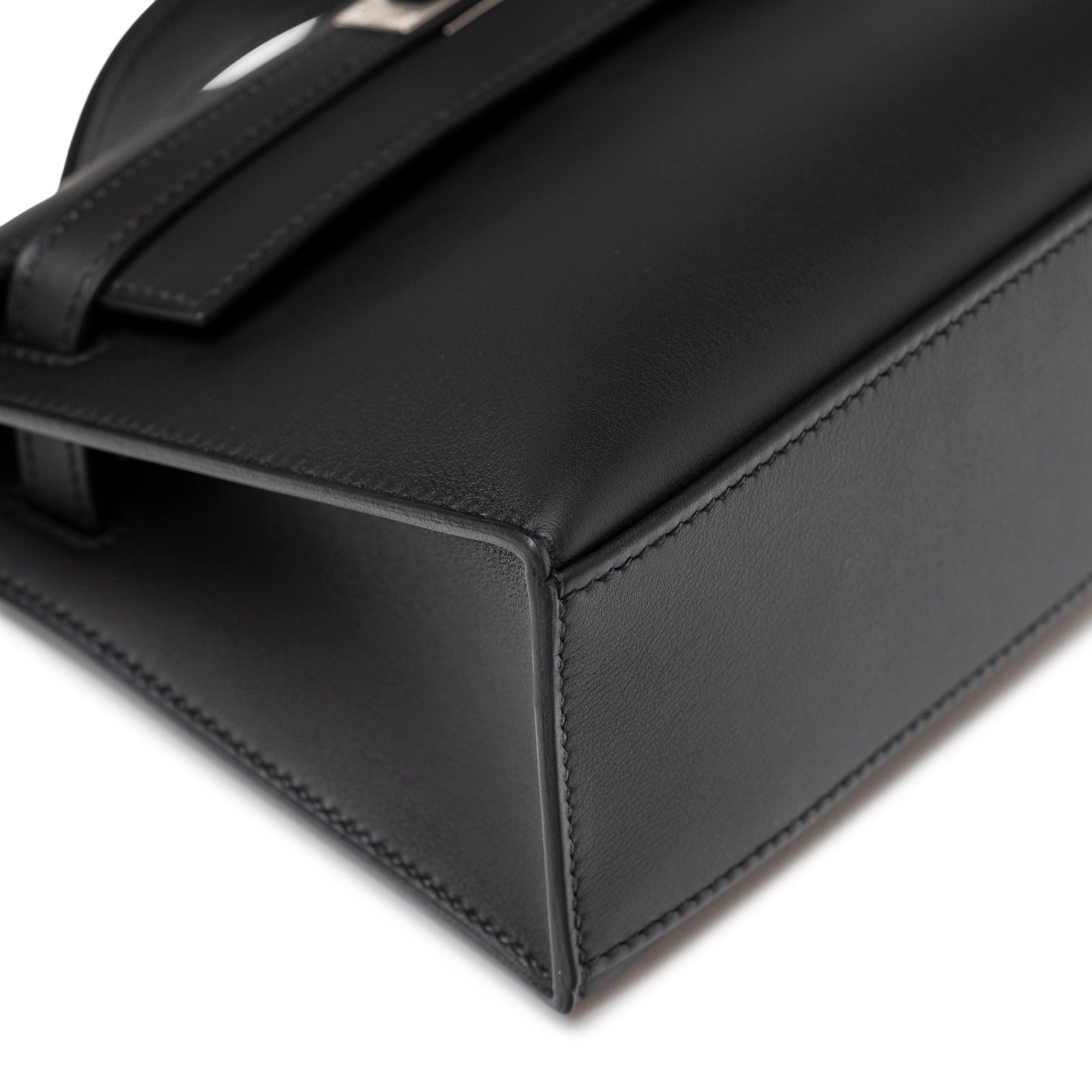 Close-up of bottom corner and smooth black leather detail on Hermès Kelly Pochette Black Swift Palladium Hardware
