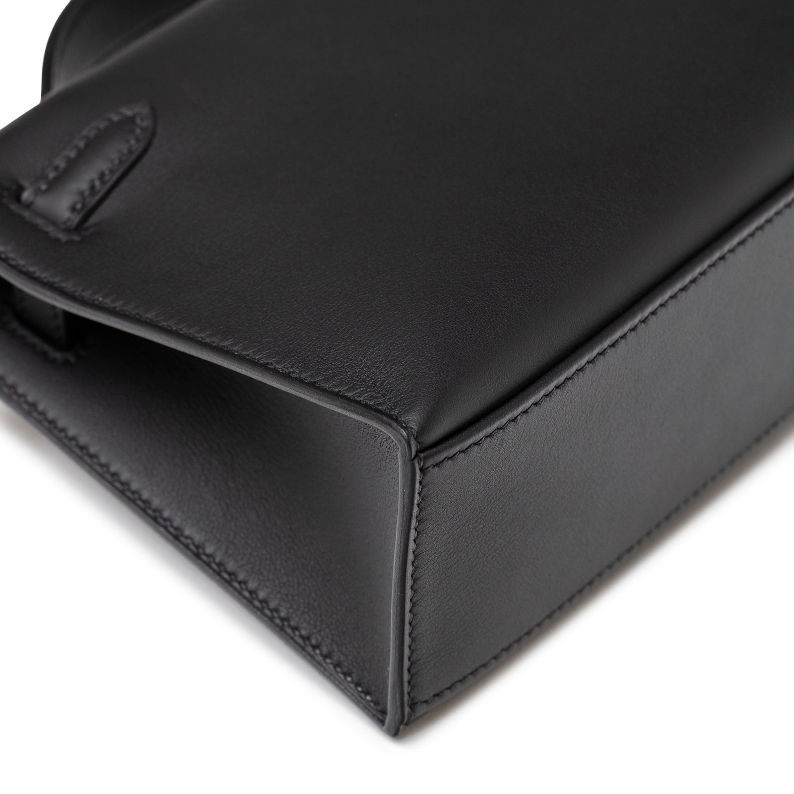 Close-up of bottom corner showing smooth black leather and precise stitching on Hermès Kelly Pochette Black Swift Palladium Hardware
