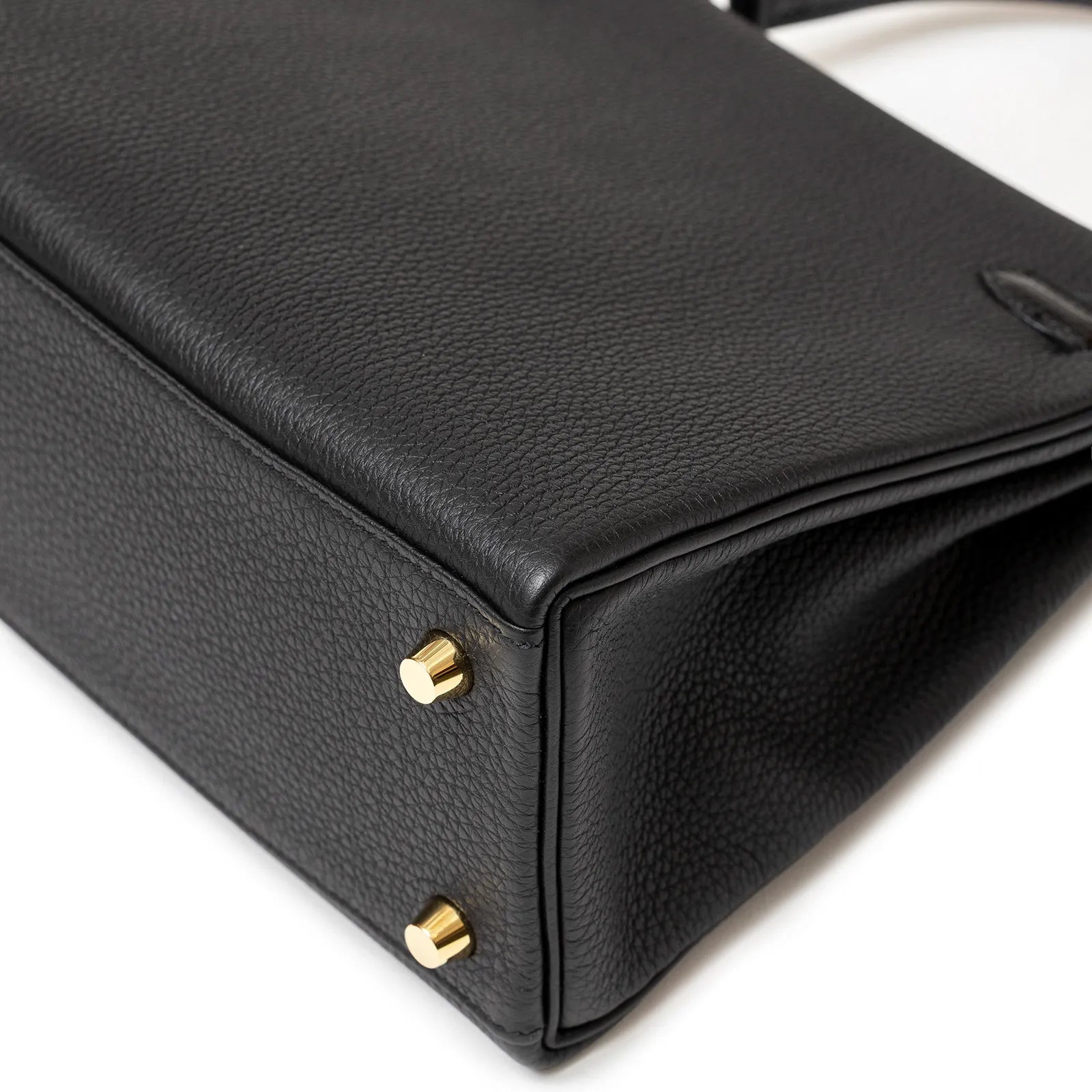 Hermès Kelly 25 Retourne Black Touch Togo/Lizard Permabrass Hardware bottom view showing pebbled leather texture and gold hardware details.