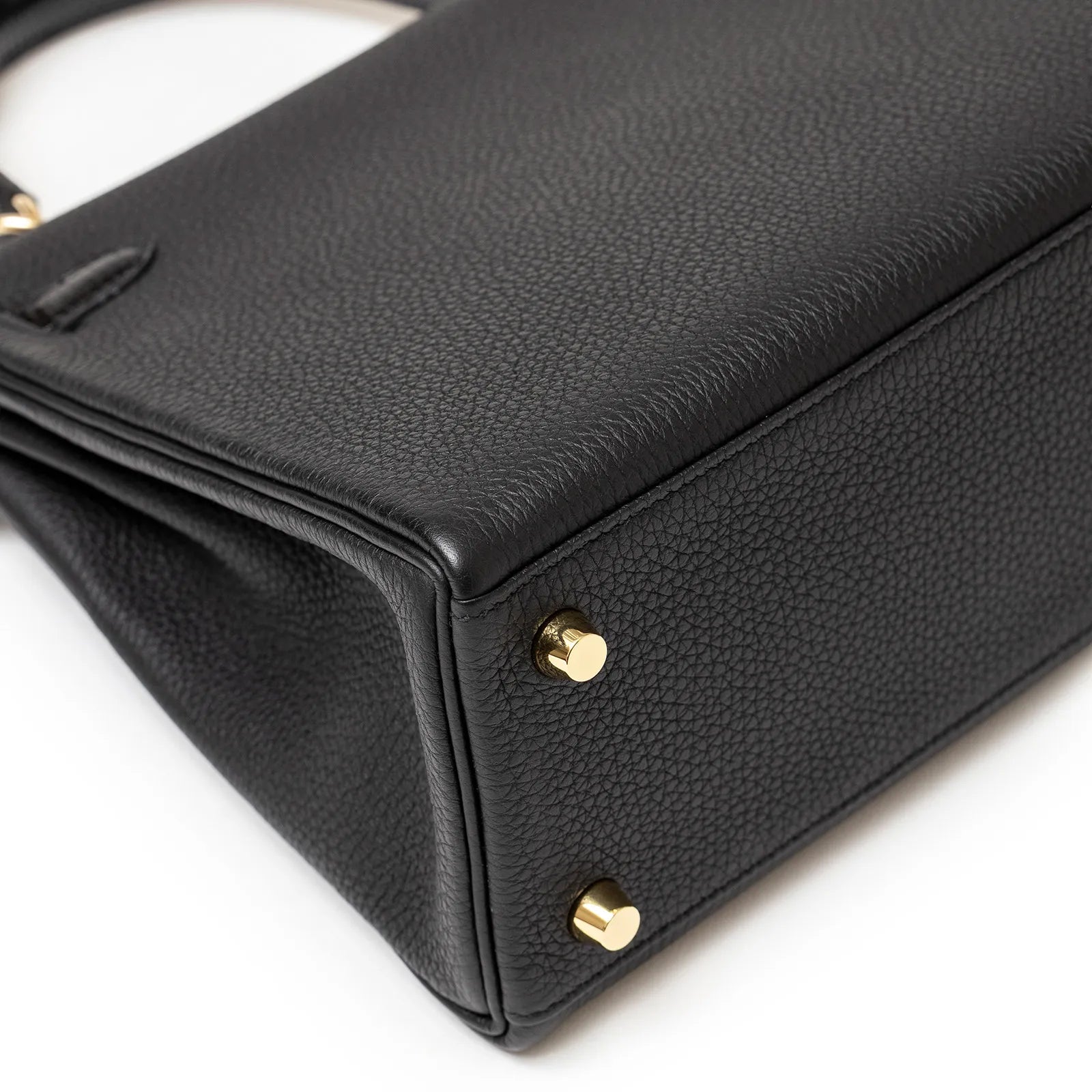 Bottom view of Hermès Kelly 25 Retourne Black Touch Togo/Lizard Permabrass Hardware handbag with gold feet detailing.