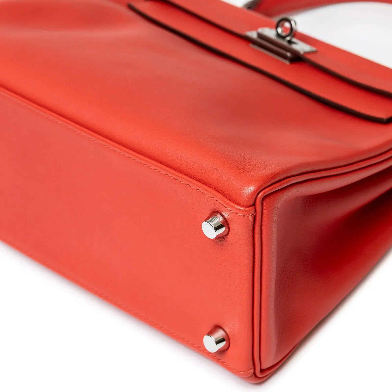 Close-up of bottom corner and palladium feet on Hermès Kelly 25 Retourne Rouge Swift Palladium Hardware handbag