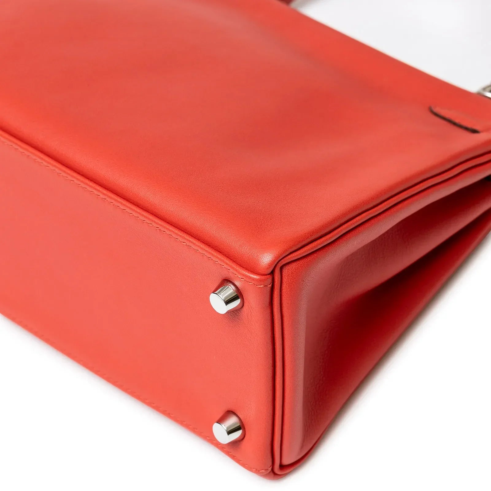 Close-up bottom view of Hermès Kelly 25 Retourne Rouge Swift Palladium Hardware showing feet and leather texture