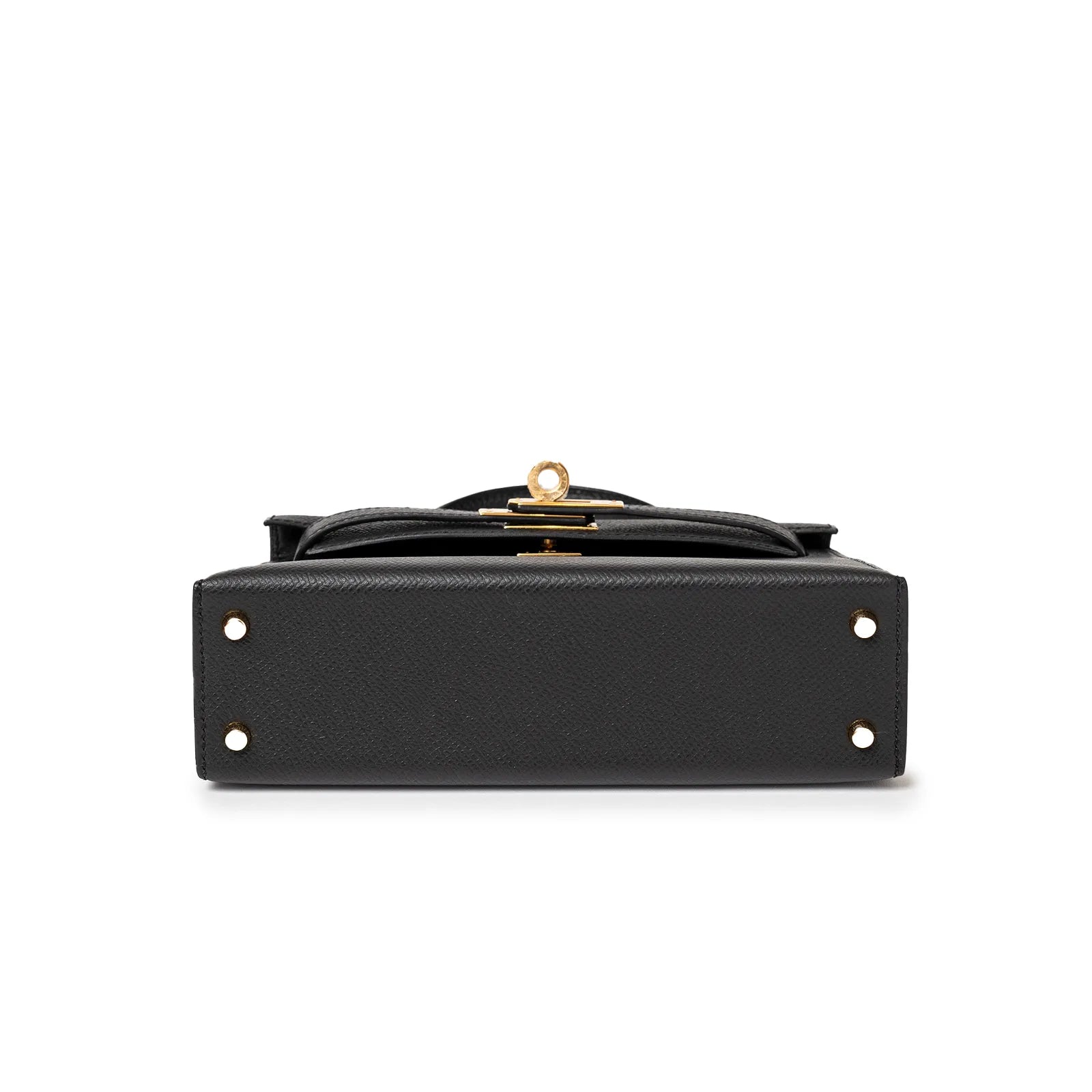 Bottom view of black leather handbag with gold clasp and four metal feet.