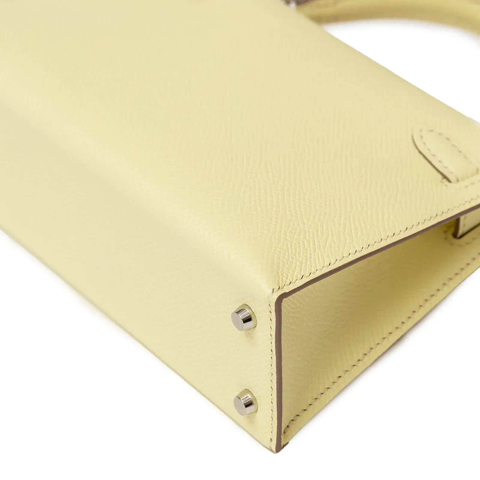 Close-up angled shot of bottom corner and palladium hardware on Hermès Mini Kelly II Sellier 20 Jaune Milton Epsom Palladium Hardware