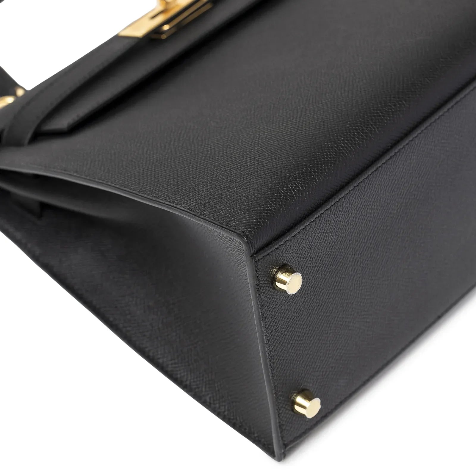 Close-up of the bottom corner showing black Epsom leather and gold studs on Hermès Kelly 28 Sellier Black Epsom Gold Hardware