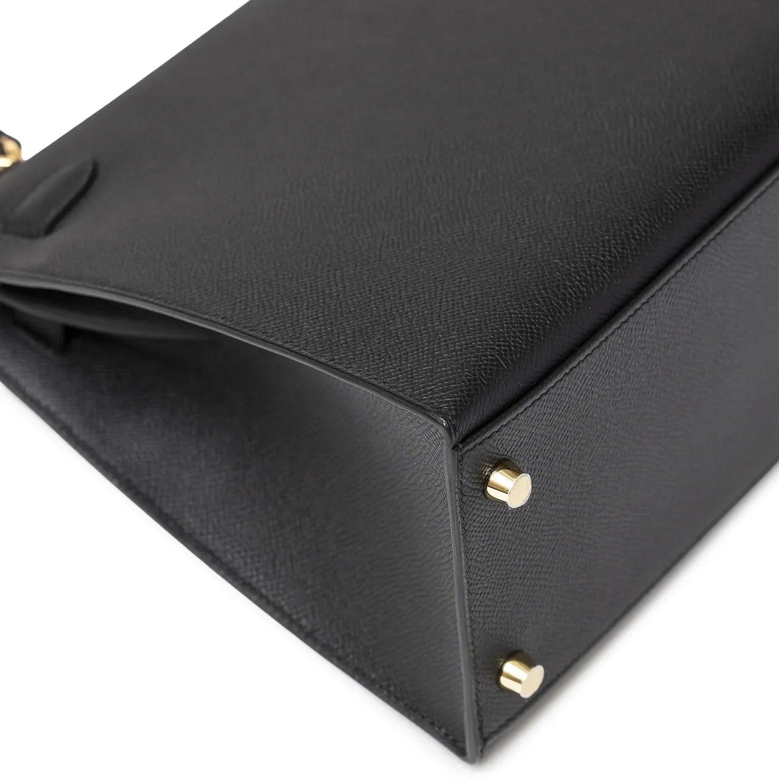 Close-up of the bottom corner showing gold hardware and textured leather of Hermès Kelly 28 Sellier Black Epsom Gold Hardware
