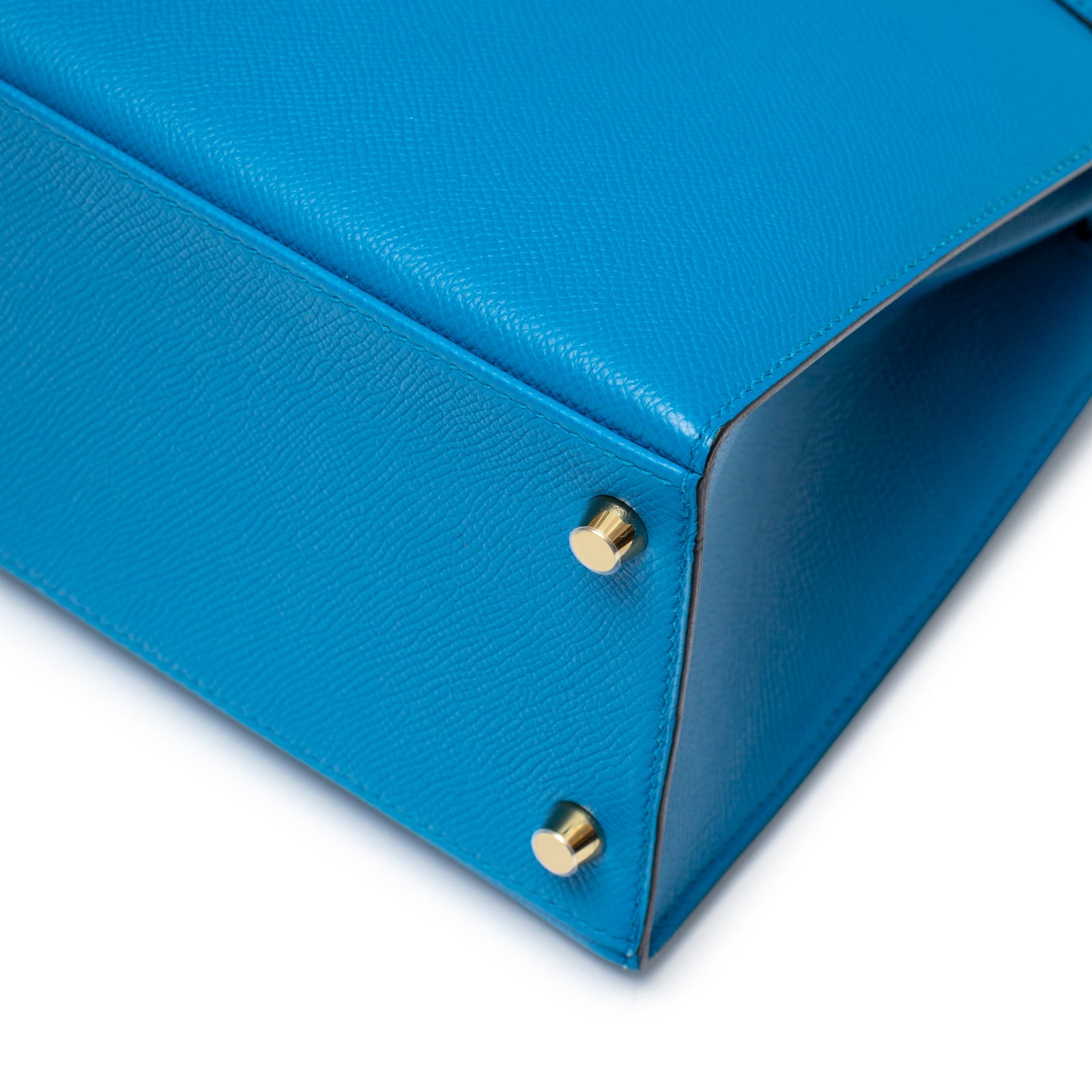 Close-up of base corner showing detailed stitching and gold hardware feet on Hermès Kelly Sellier 28 Blue Zanzibar Epsom Gold Hardware