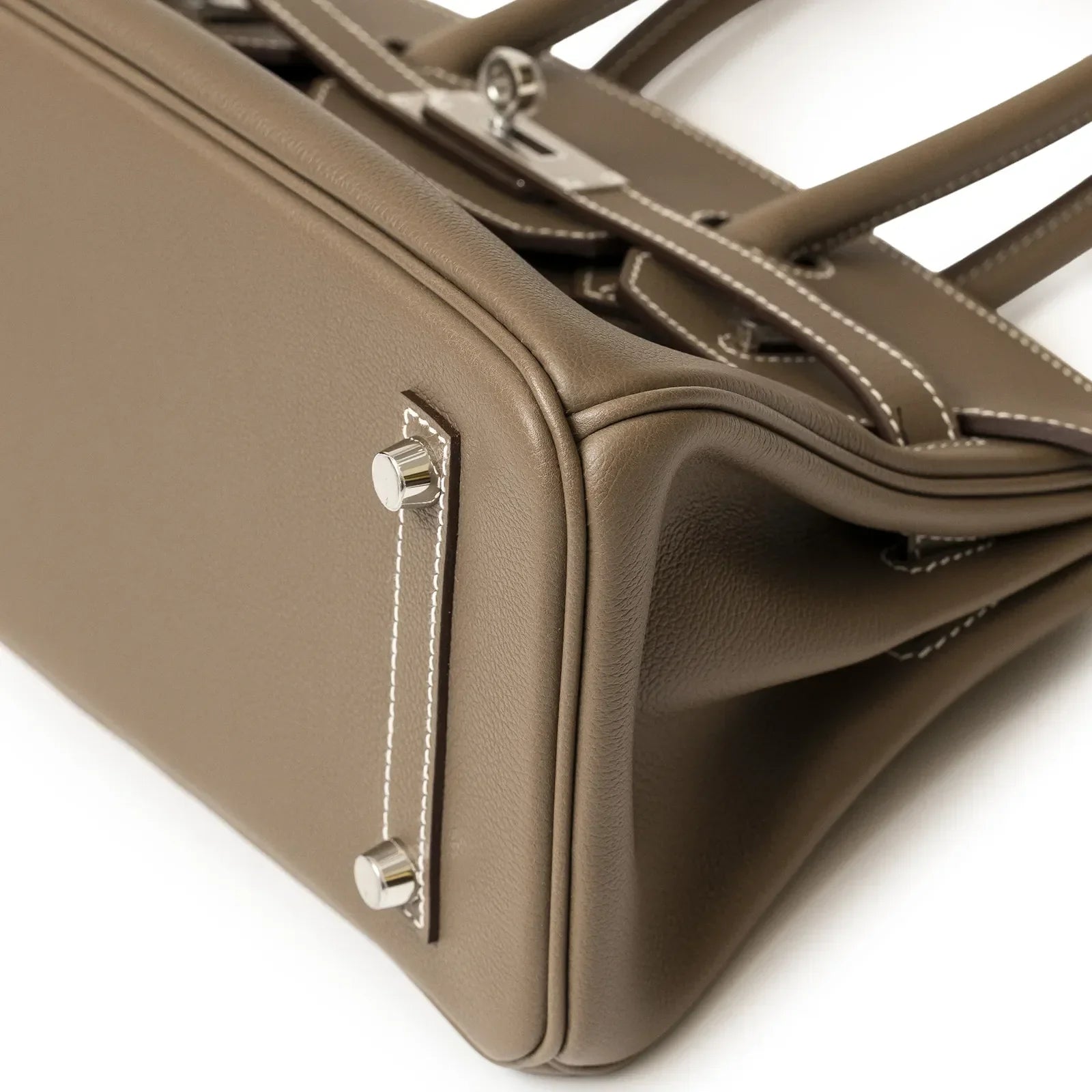 Close-up bottom corner view of Hermès Birkin 29 Etoupe Evercolor leather with palladium hardware feet and stitching detail